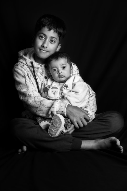 An older brother holding his baby sibling