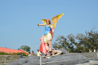 Statue of an angel stepping on a fallen figure