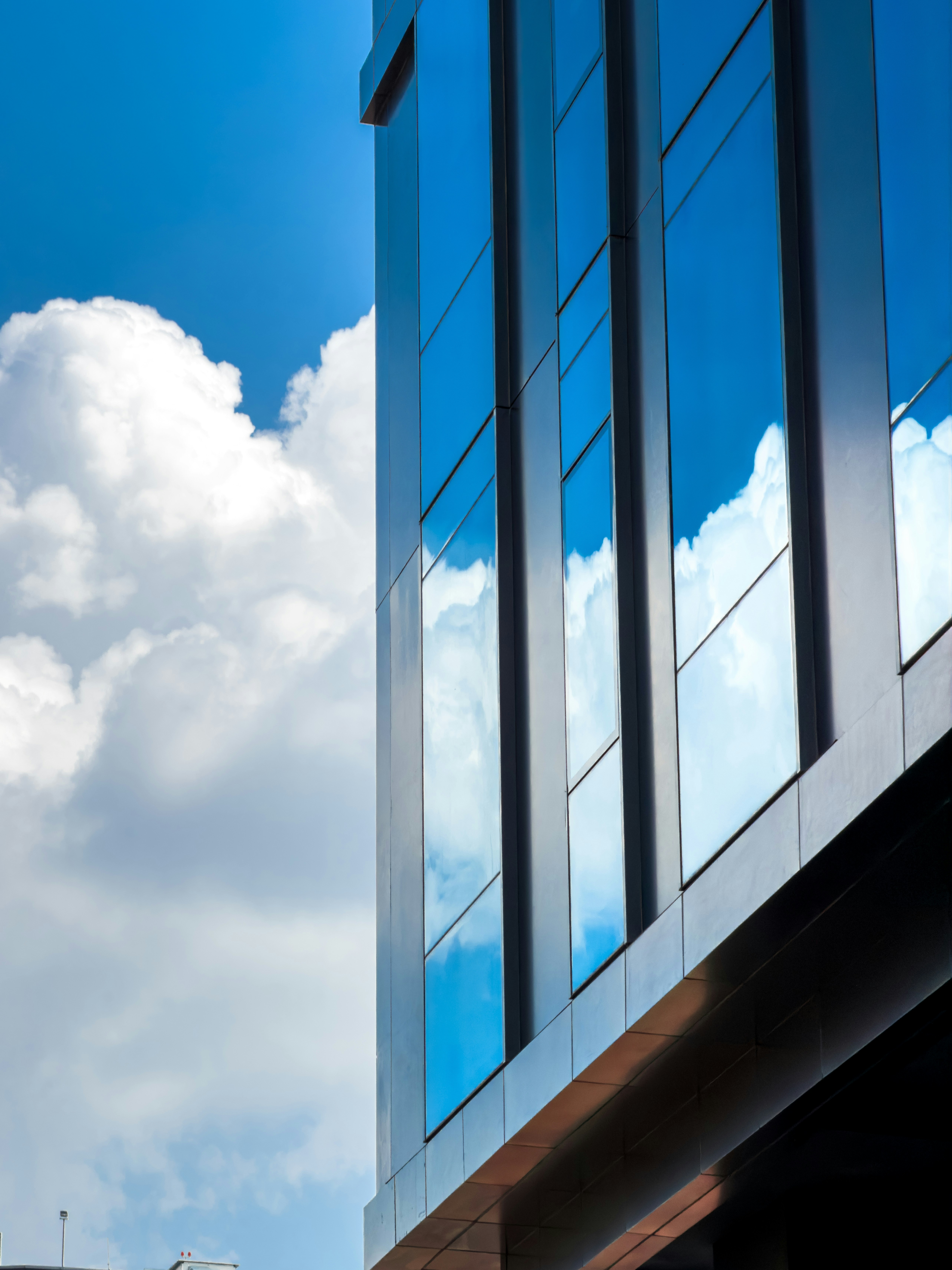 Blue sky and clouds reflected in modern building windows