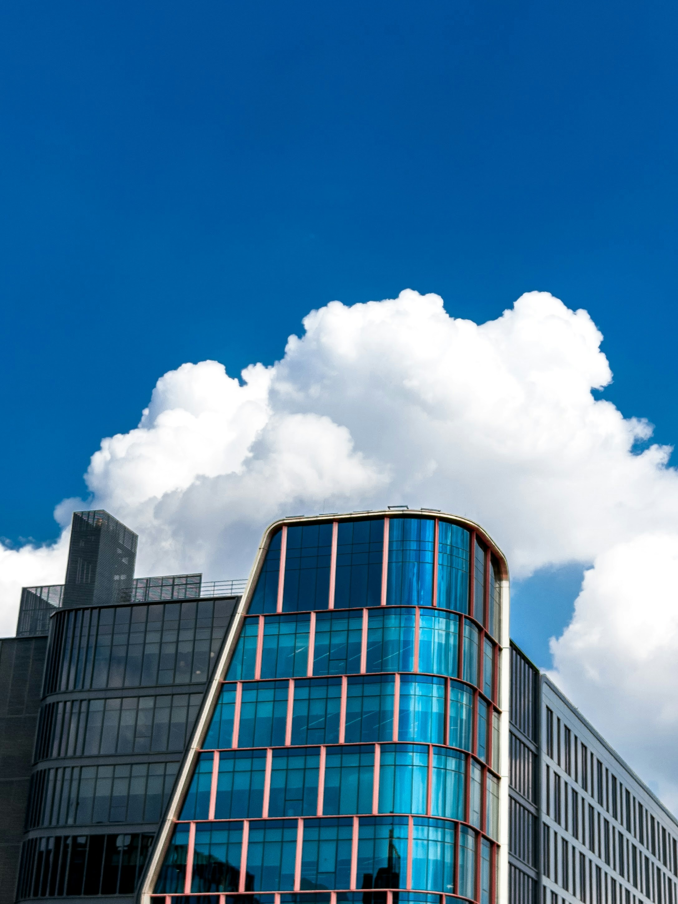 Modern glass buildings against a bright blue sky.