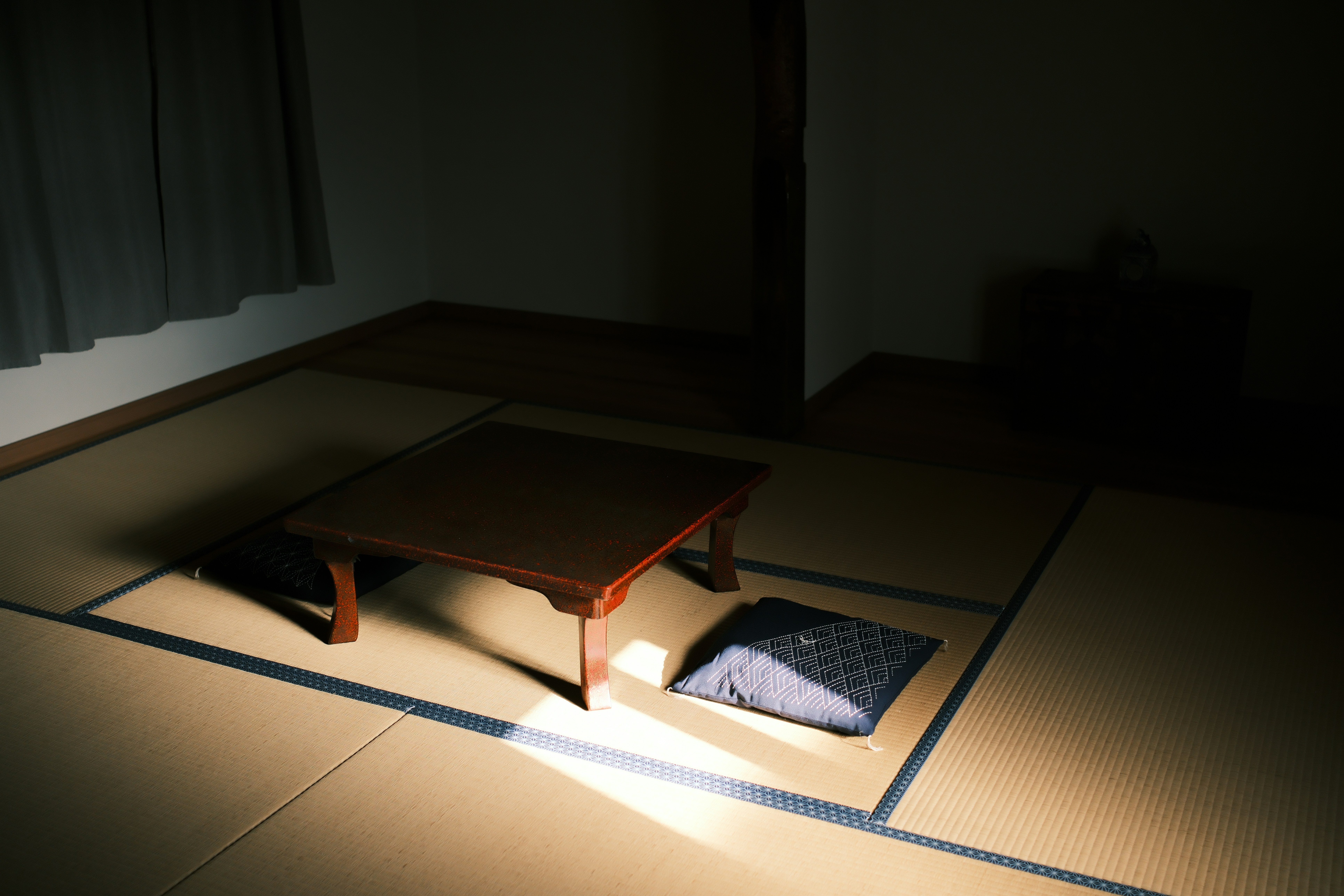 Person's legs under a desk with an electric foot warmer mat, working on a laptop