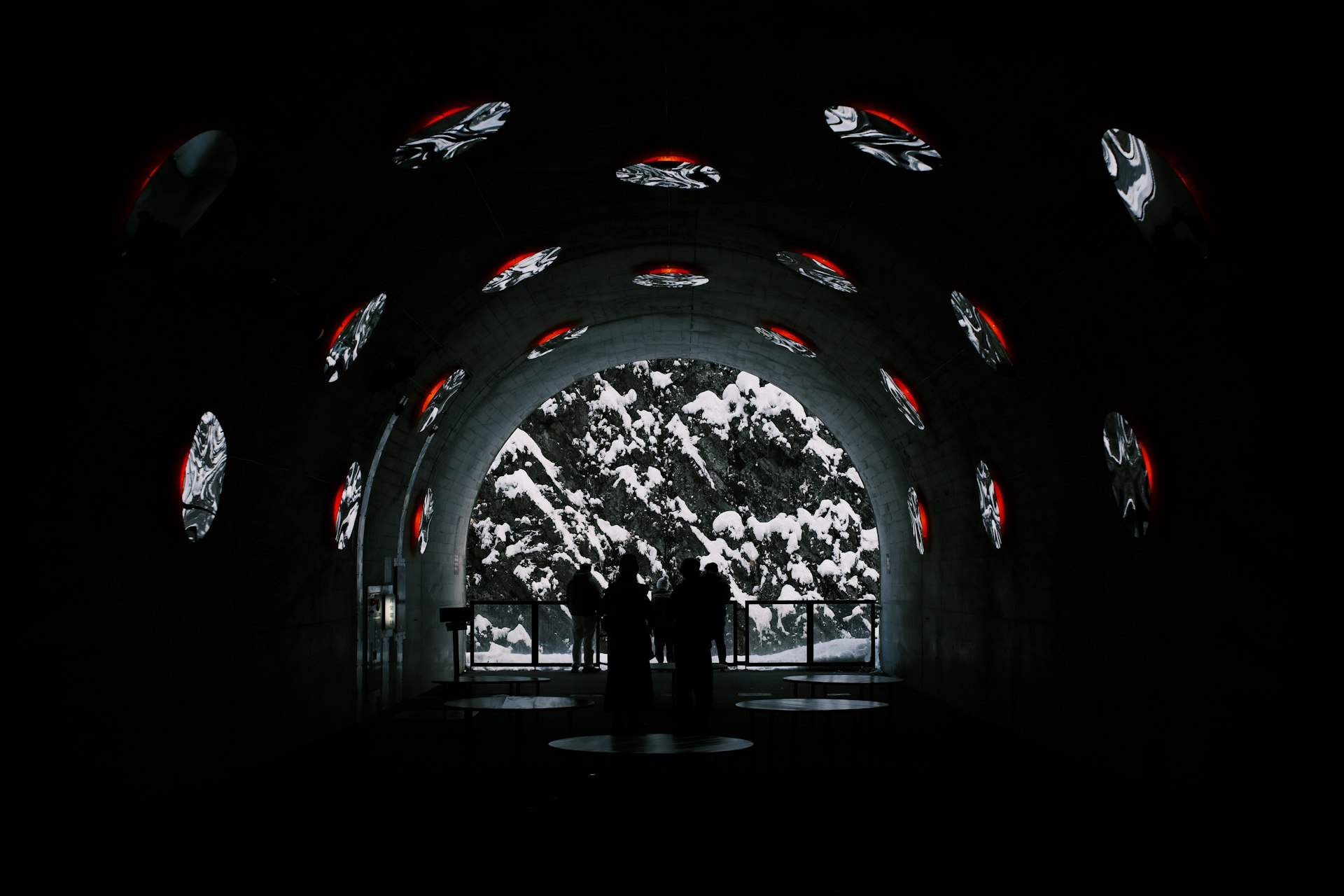 People walk through a tunnel with projected images.
