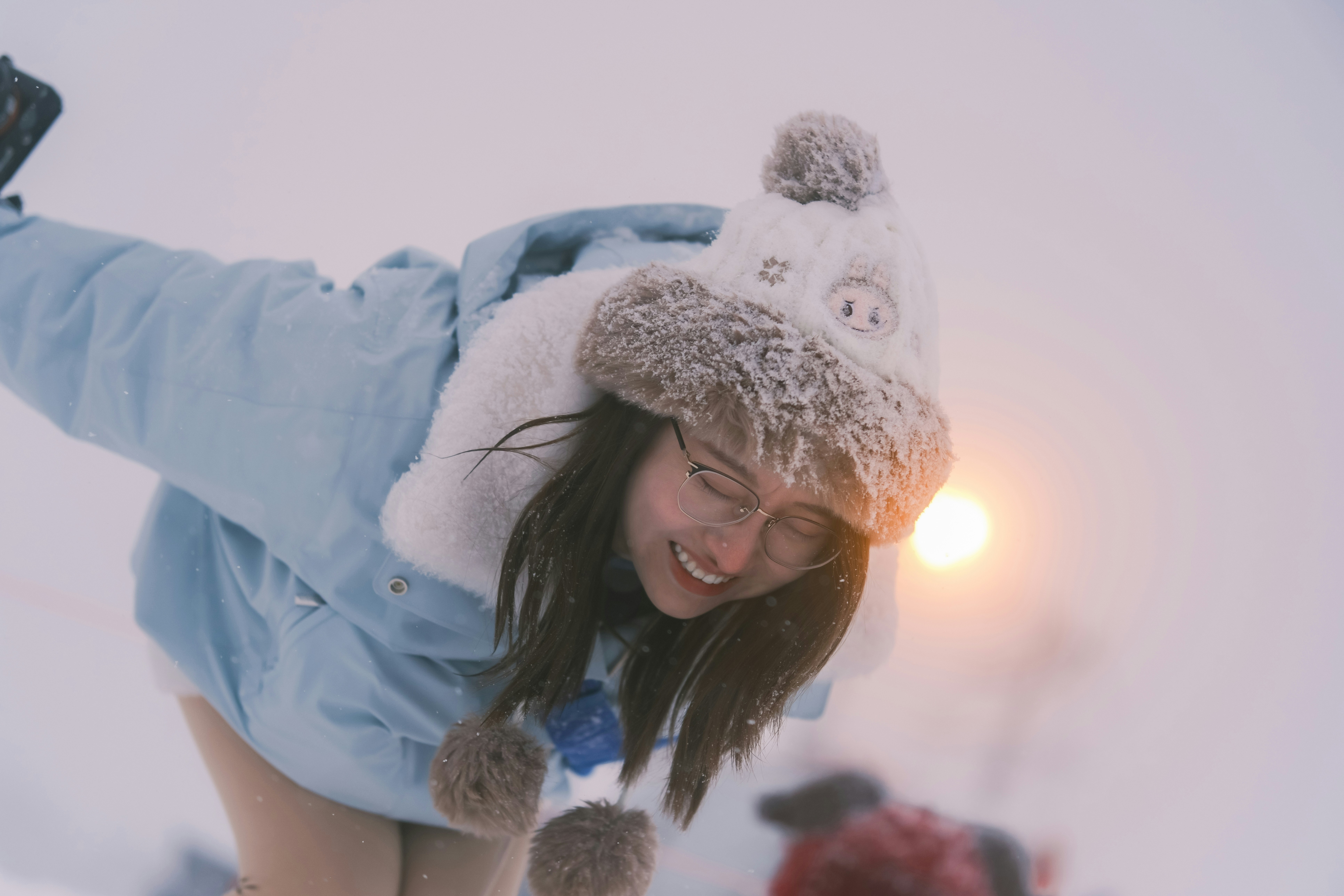 Group of friends laughing while sledding down a snowy hill, a child giggling