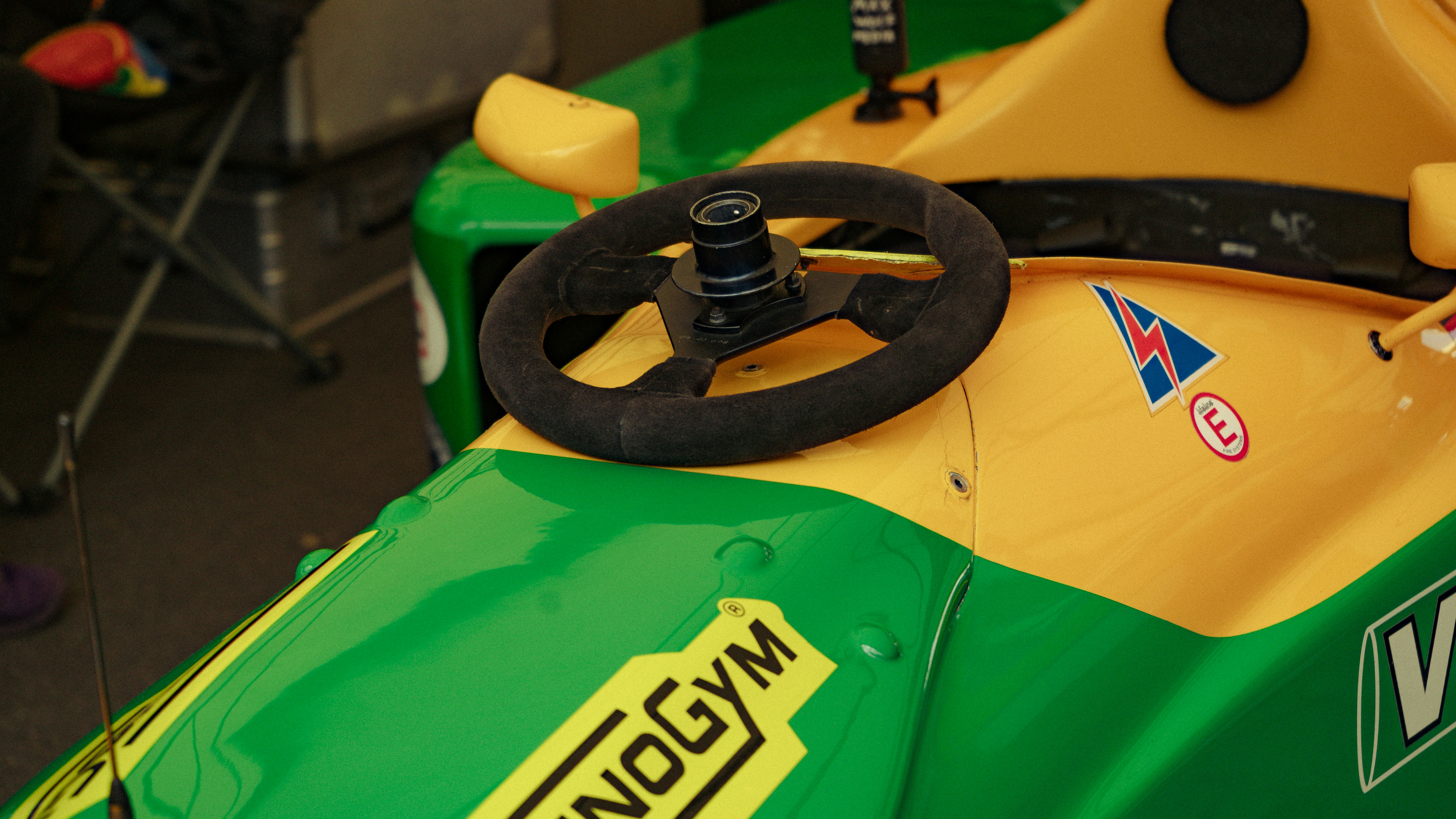 Close-up of a yellow and green go-kart steering wheel