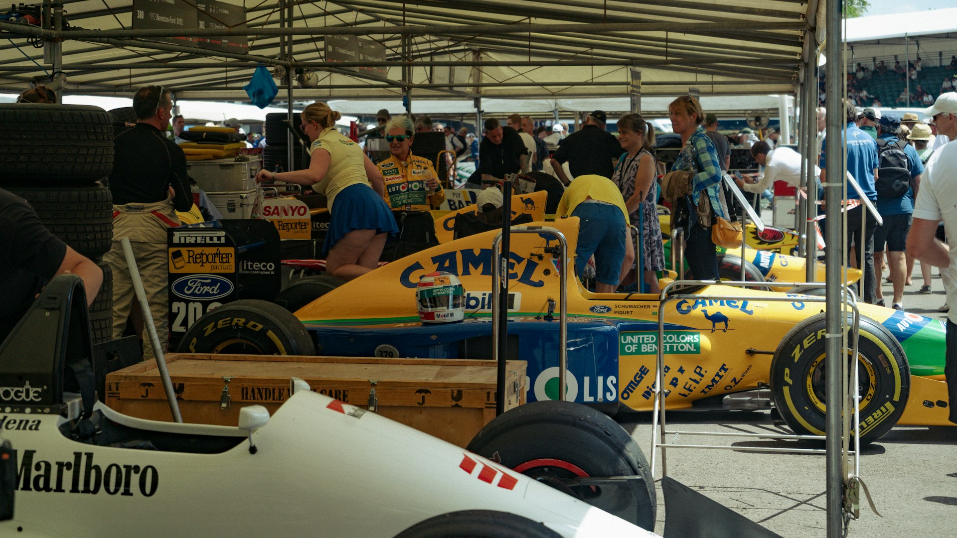 F1ピットレーンでメカニックに囲まれるフォーミュラカー