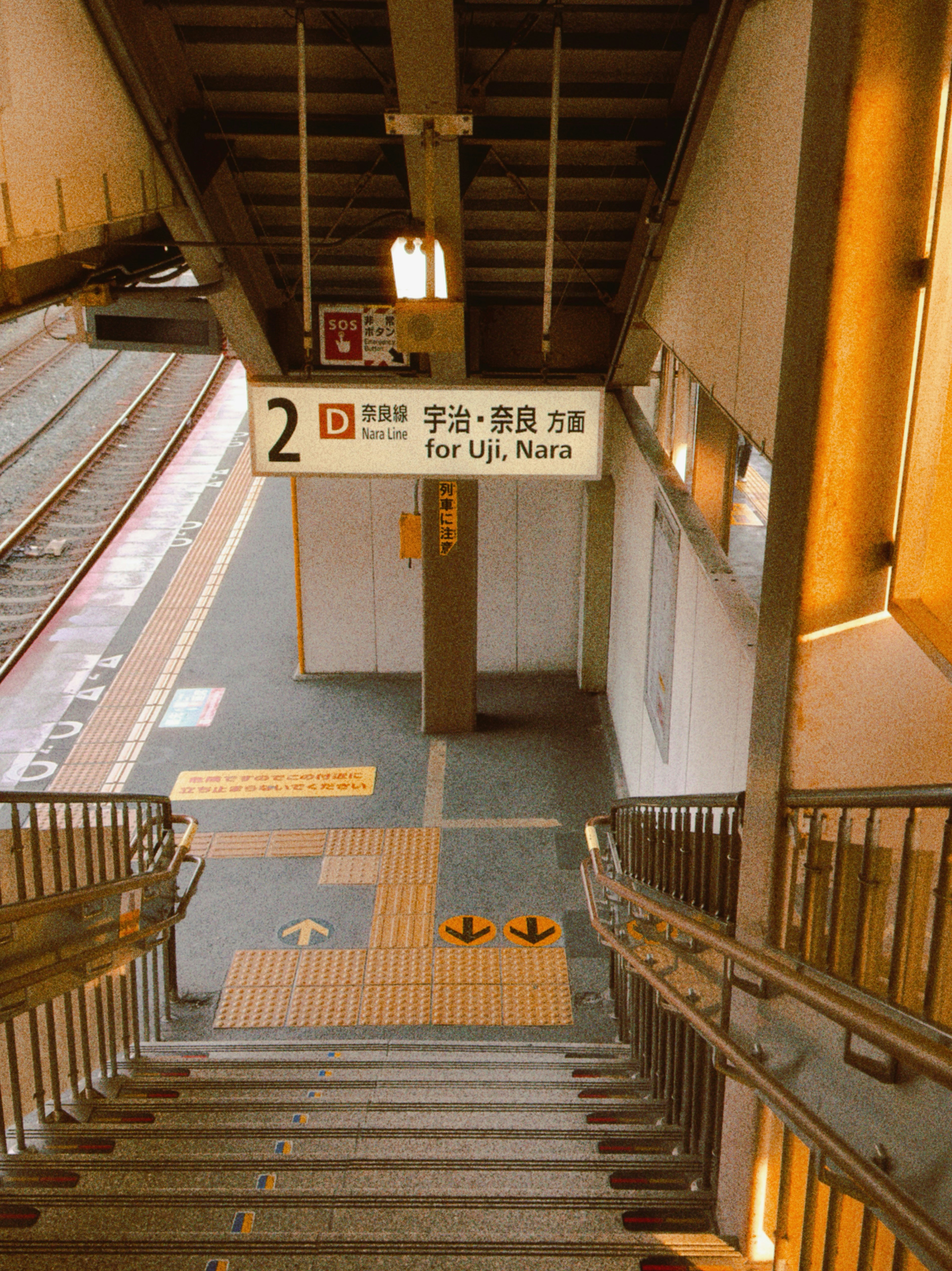Train station platform with stairs and signage