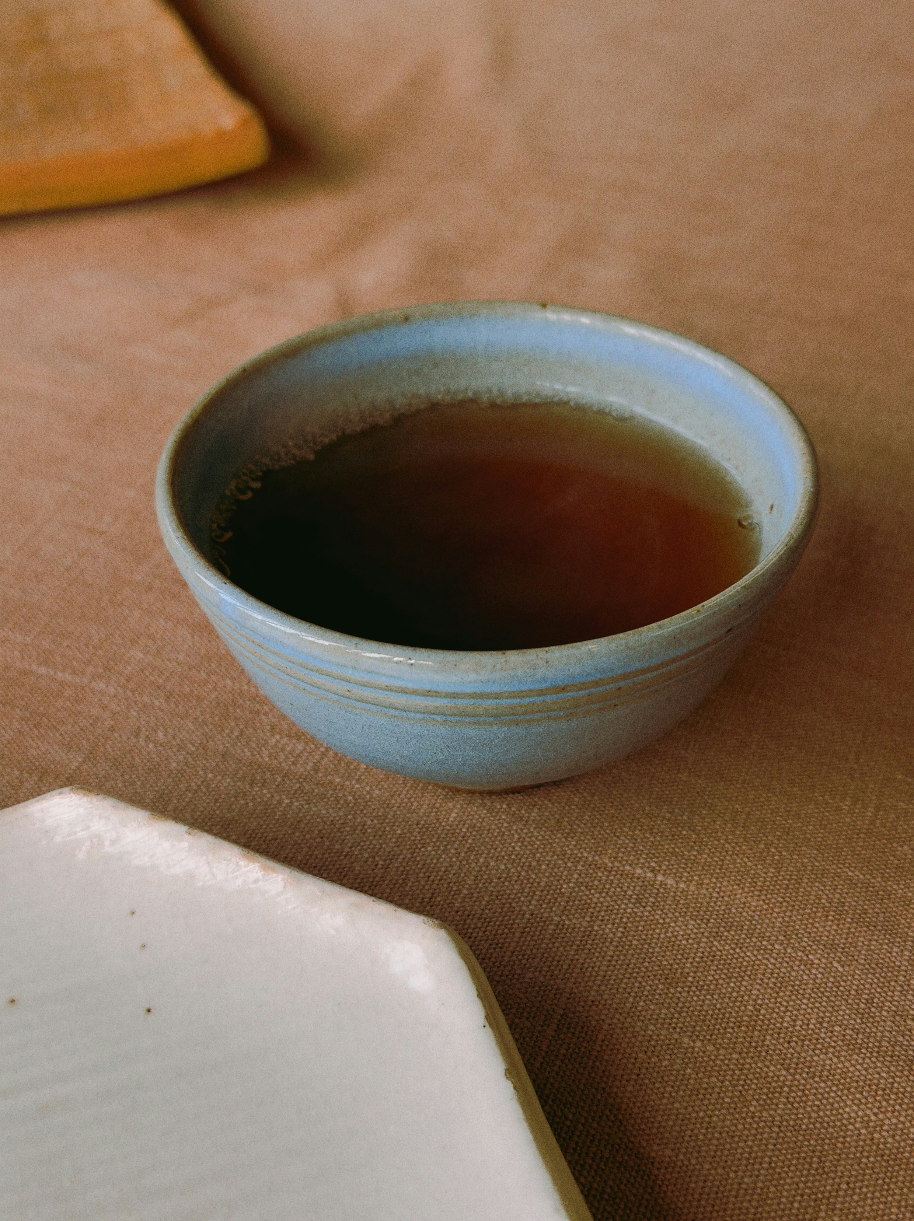 A light blue bowl filled with dark liquid.