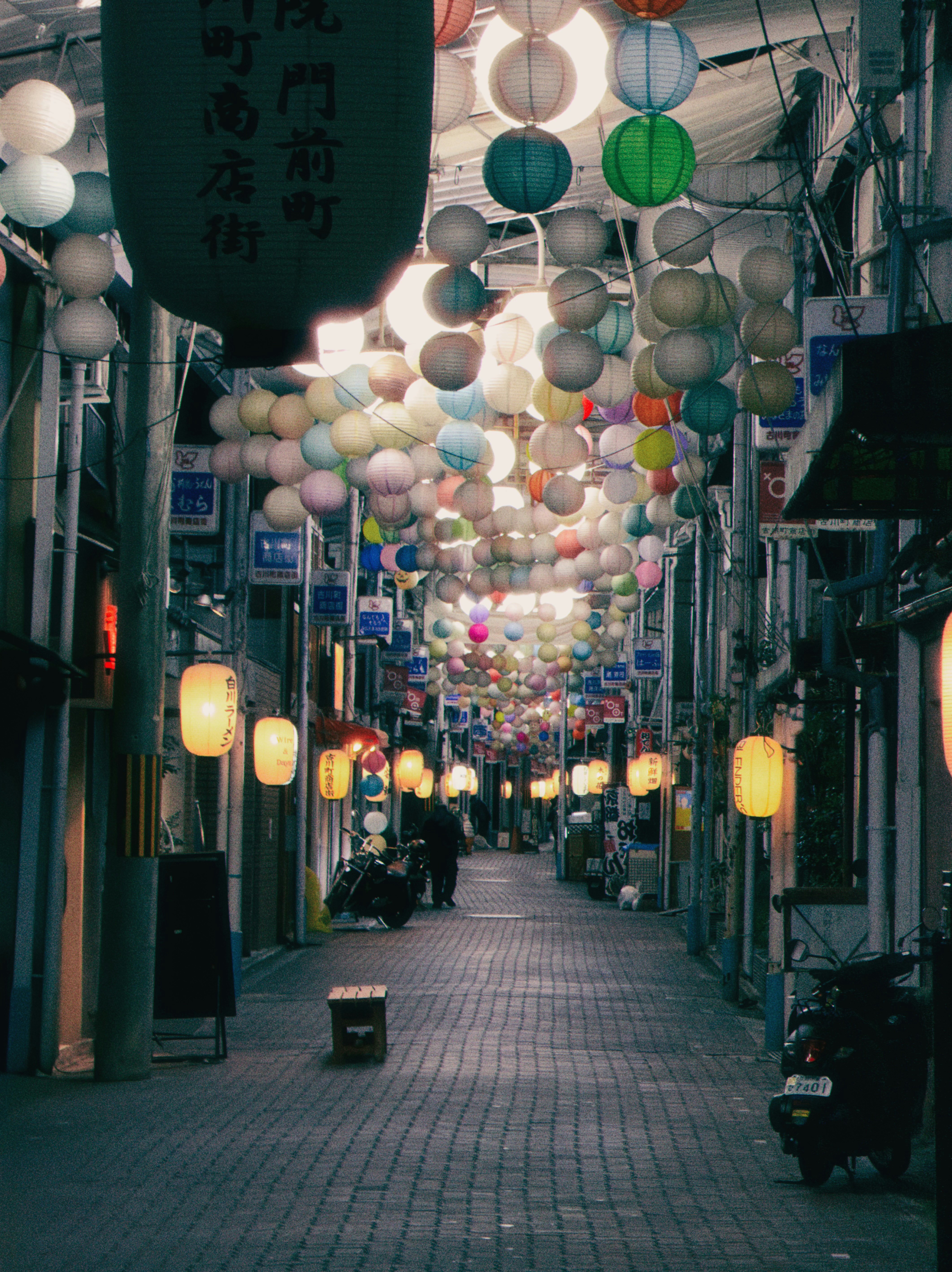 Colorful lanterns illuminate a narrow street at night.