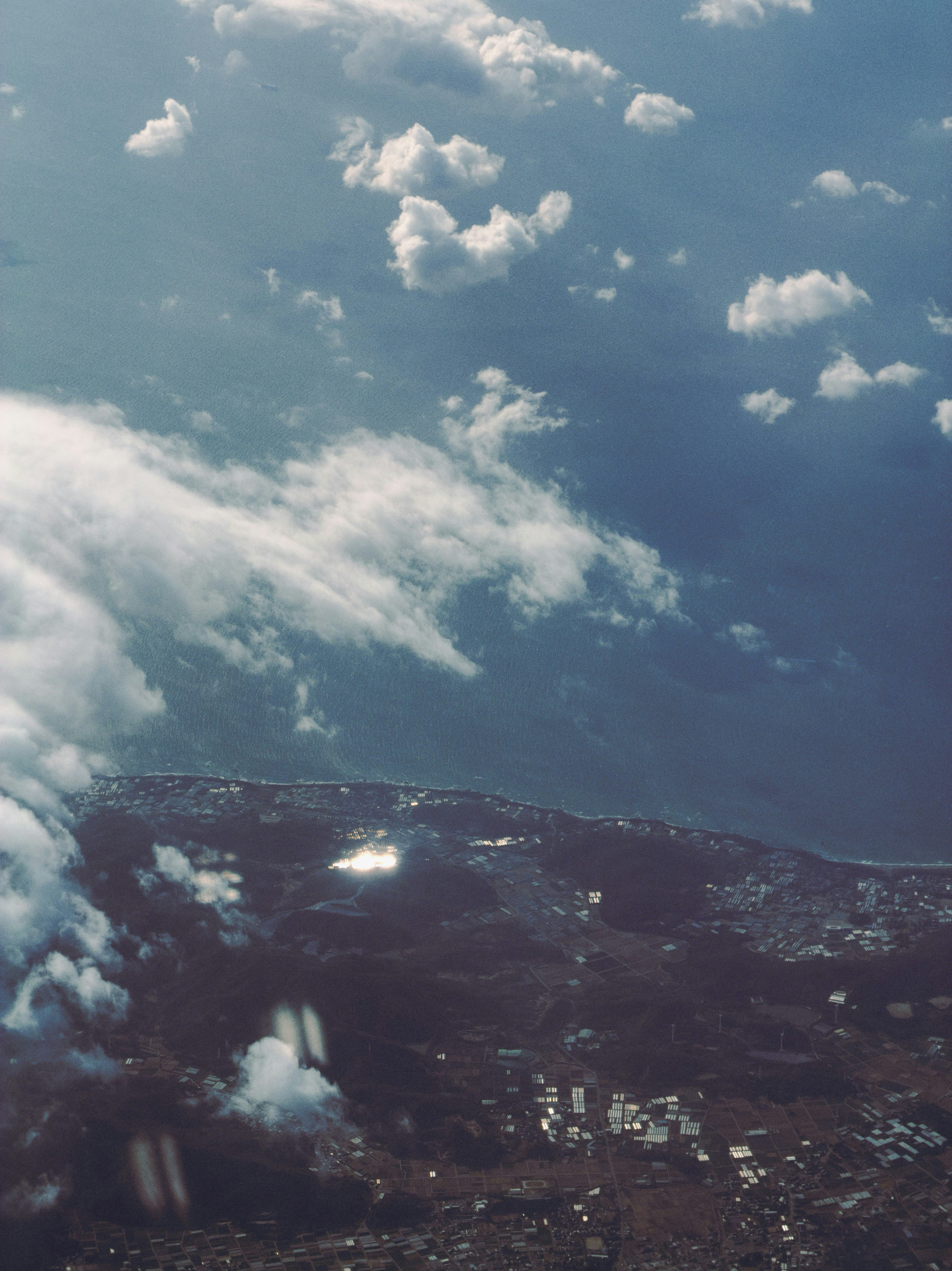 Aerial view of coastal city under dramatic clouds.