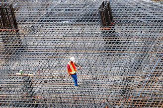 Construction worker inspects rebar on a building site.