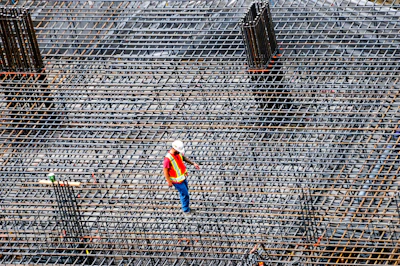 Construction worker inspects rebar on a building site.