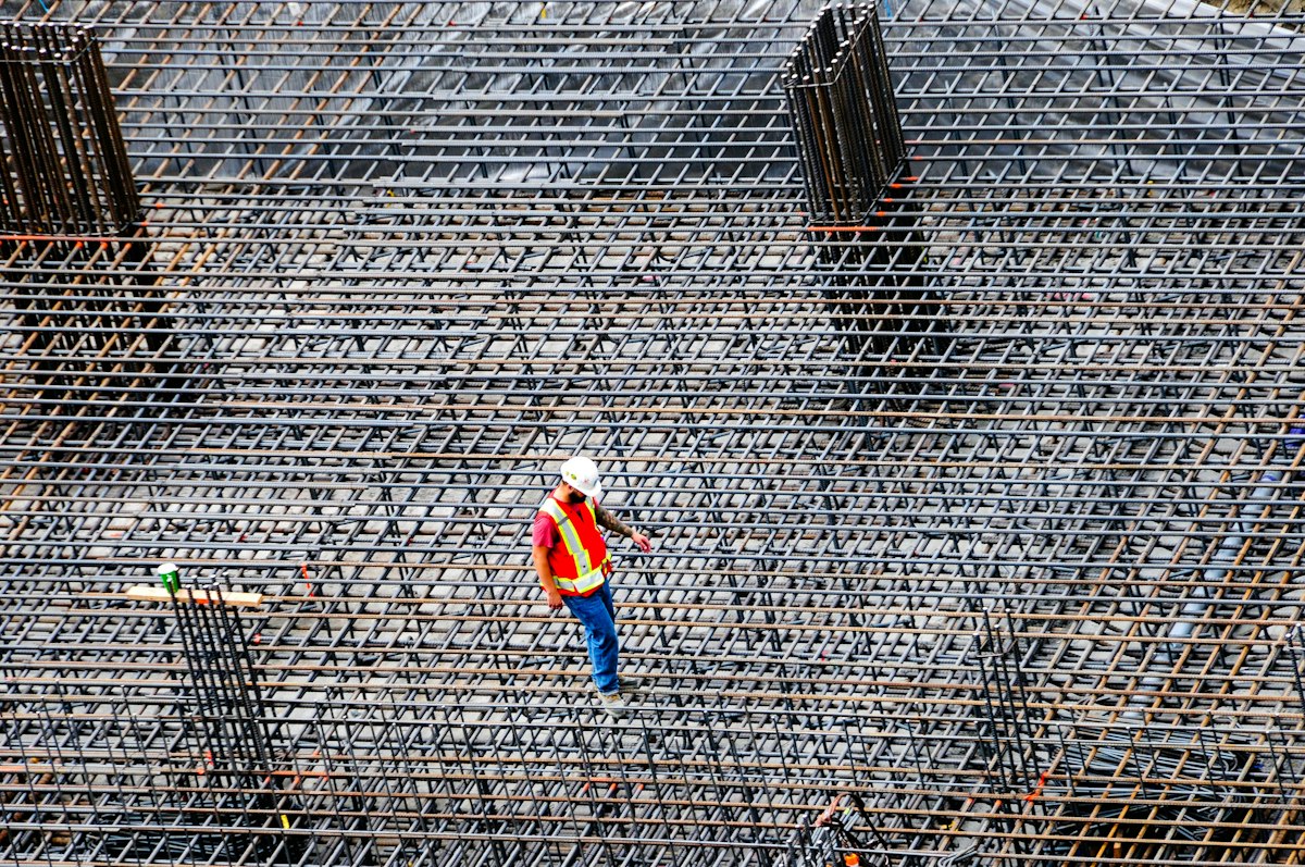 Trabalhador a verificar as armaduras de uma laje antes da betonagem numa obra