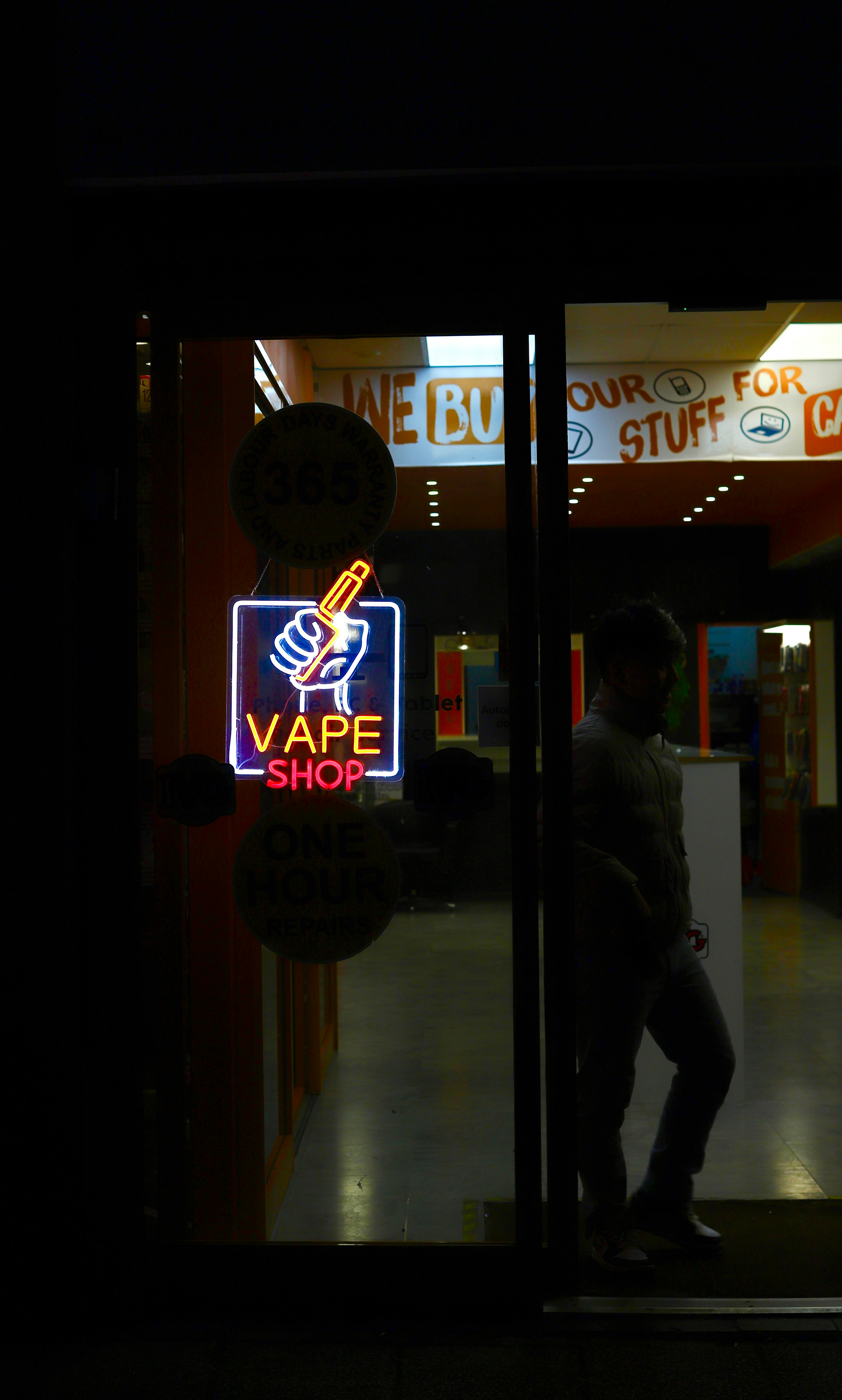 Neon vape shop sign with a silhouette of a person.
