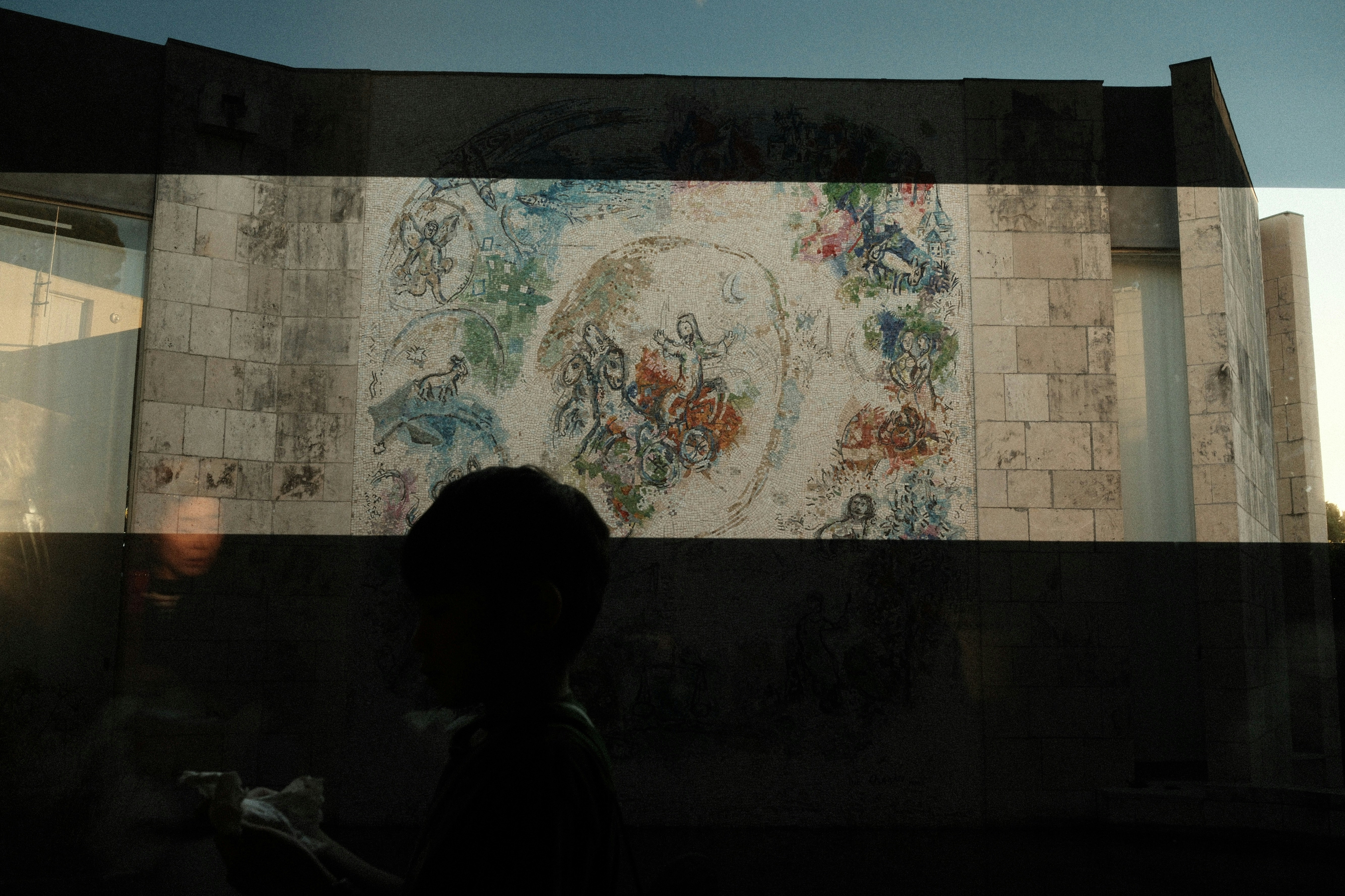 Building with colorful mural and silhouetted person