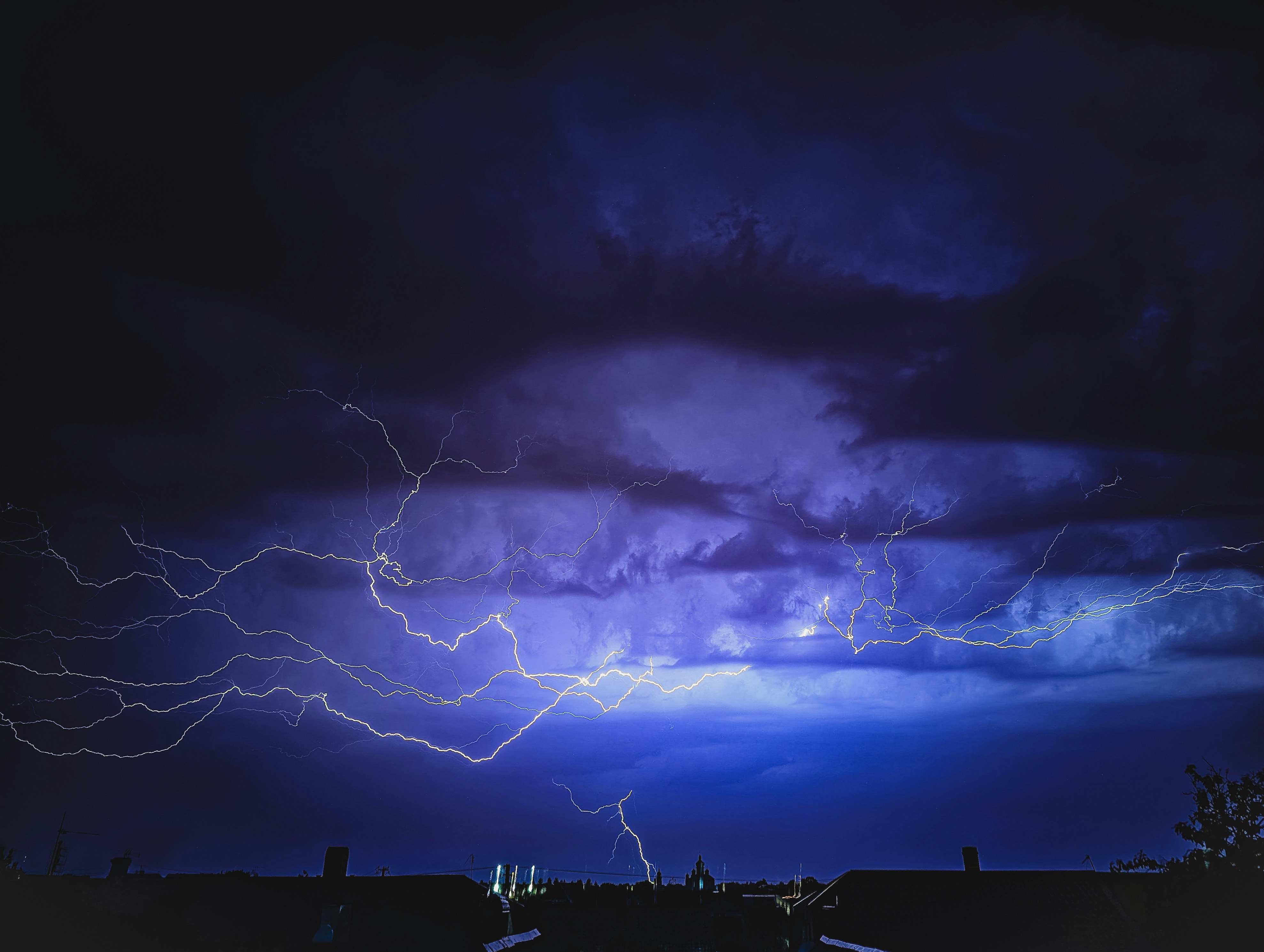 Lightning strikes illuminate the dark stormy sky