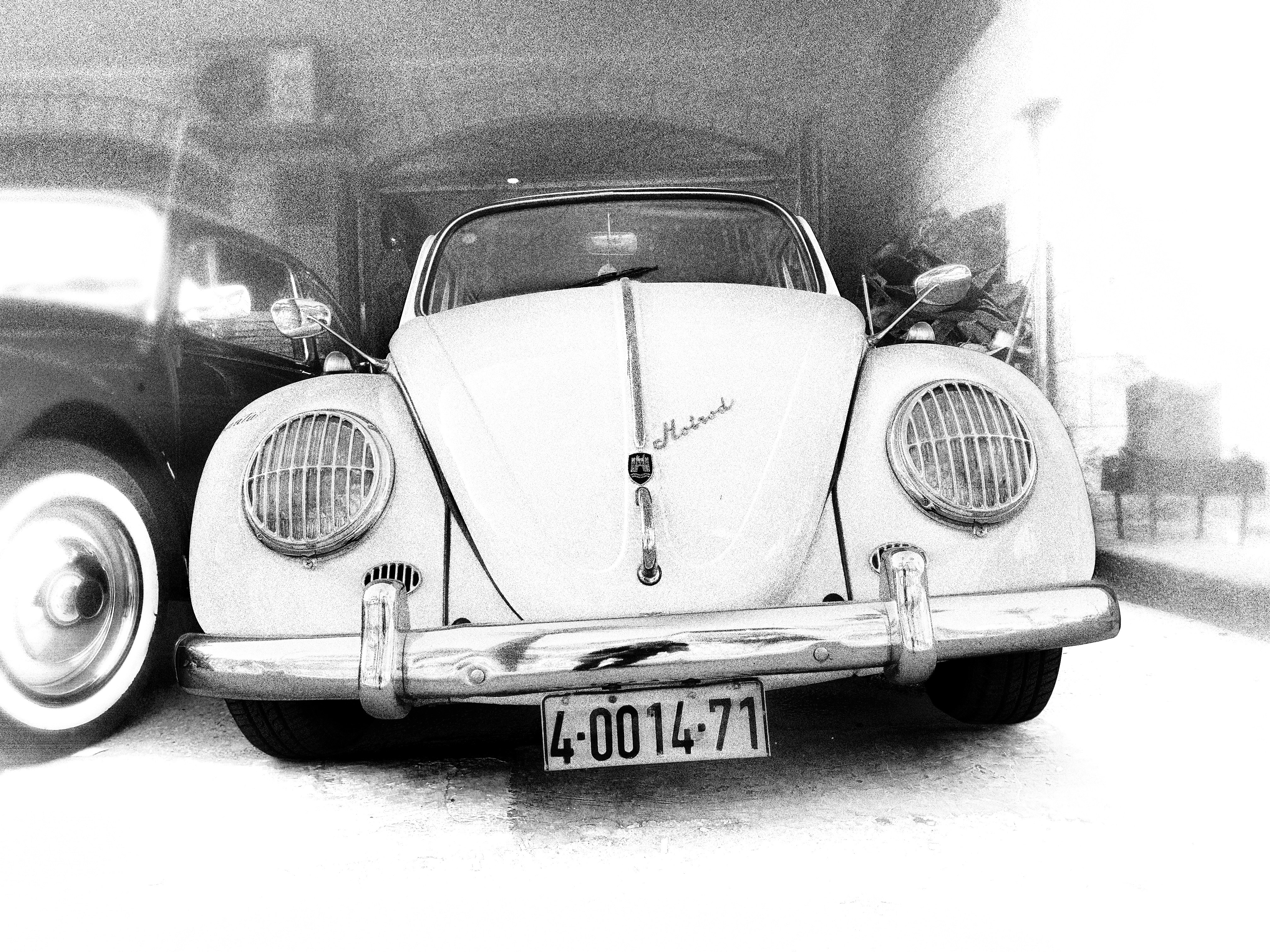 Un Volkswagen Beetle blanco aparcado al aire libre.