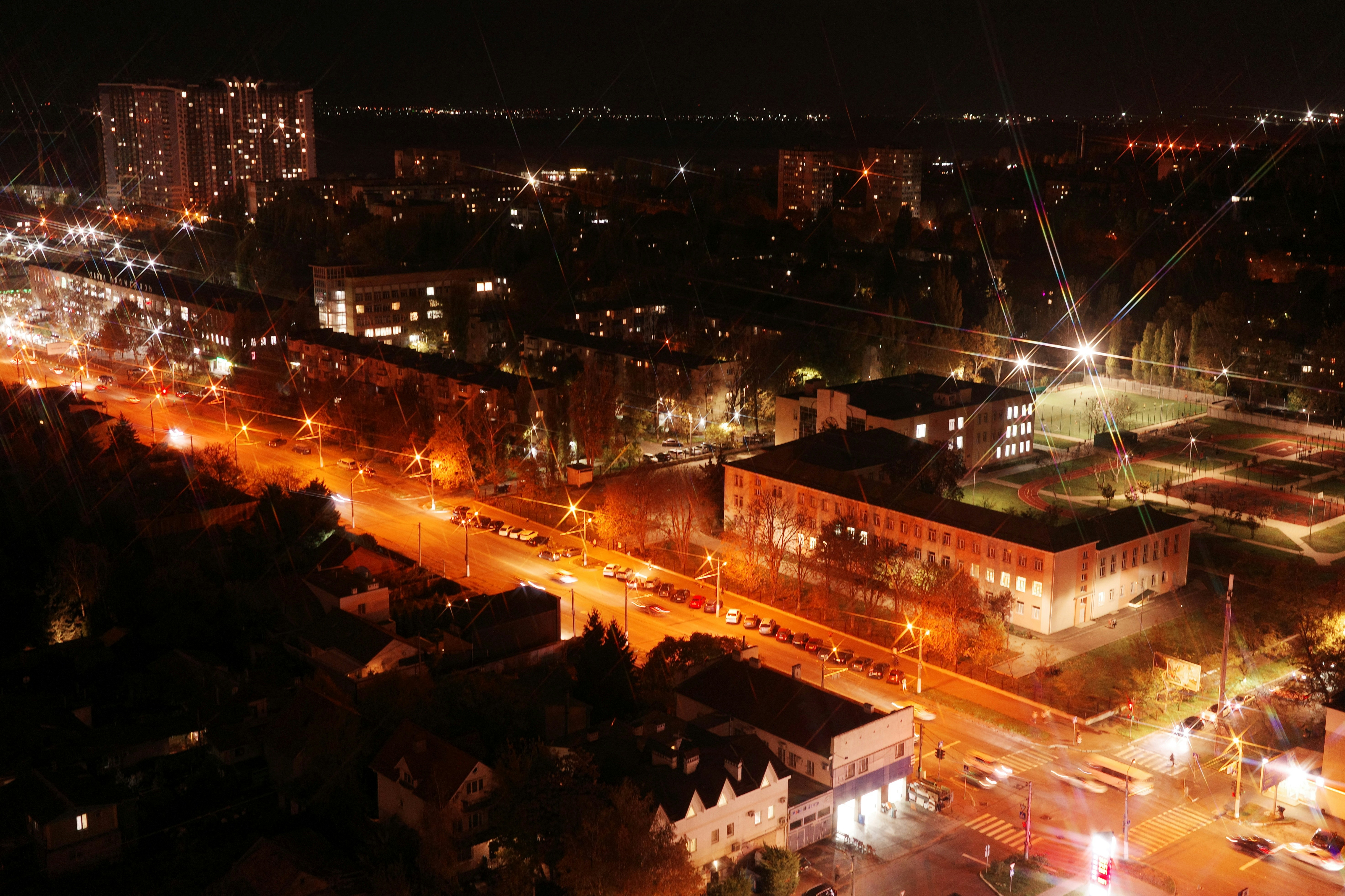 Aerial view of a city at night with glowing lights.