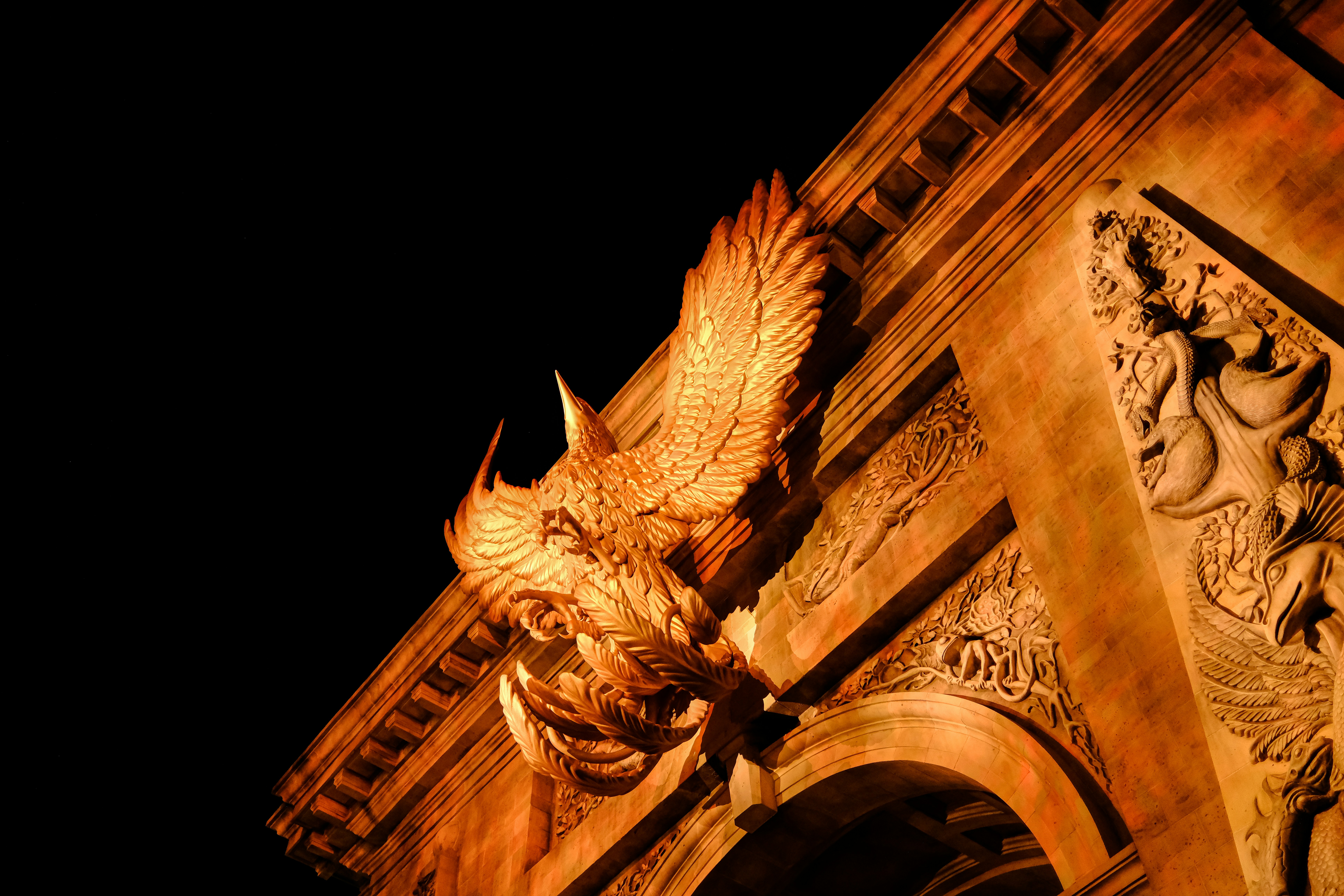 Ornate stone carving of a winged creature on building