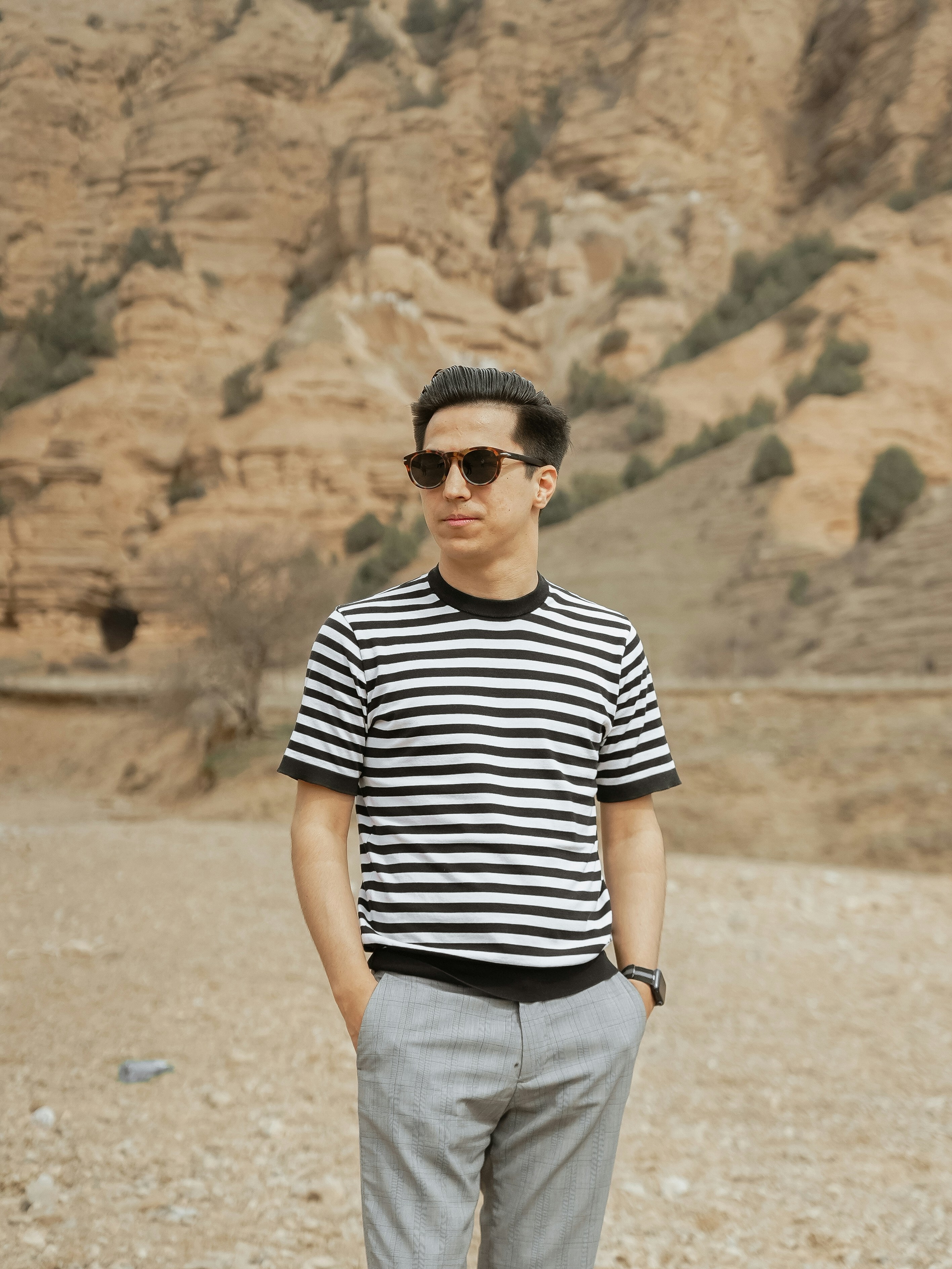 Man in striped shirt and sunglasses in desert landscape