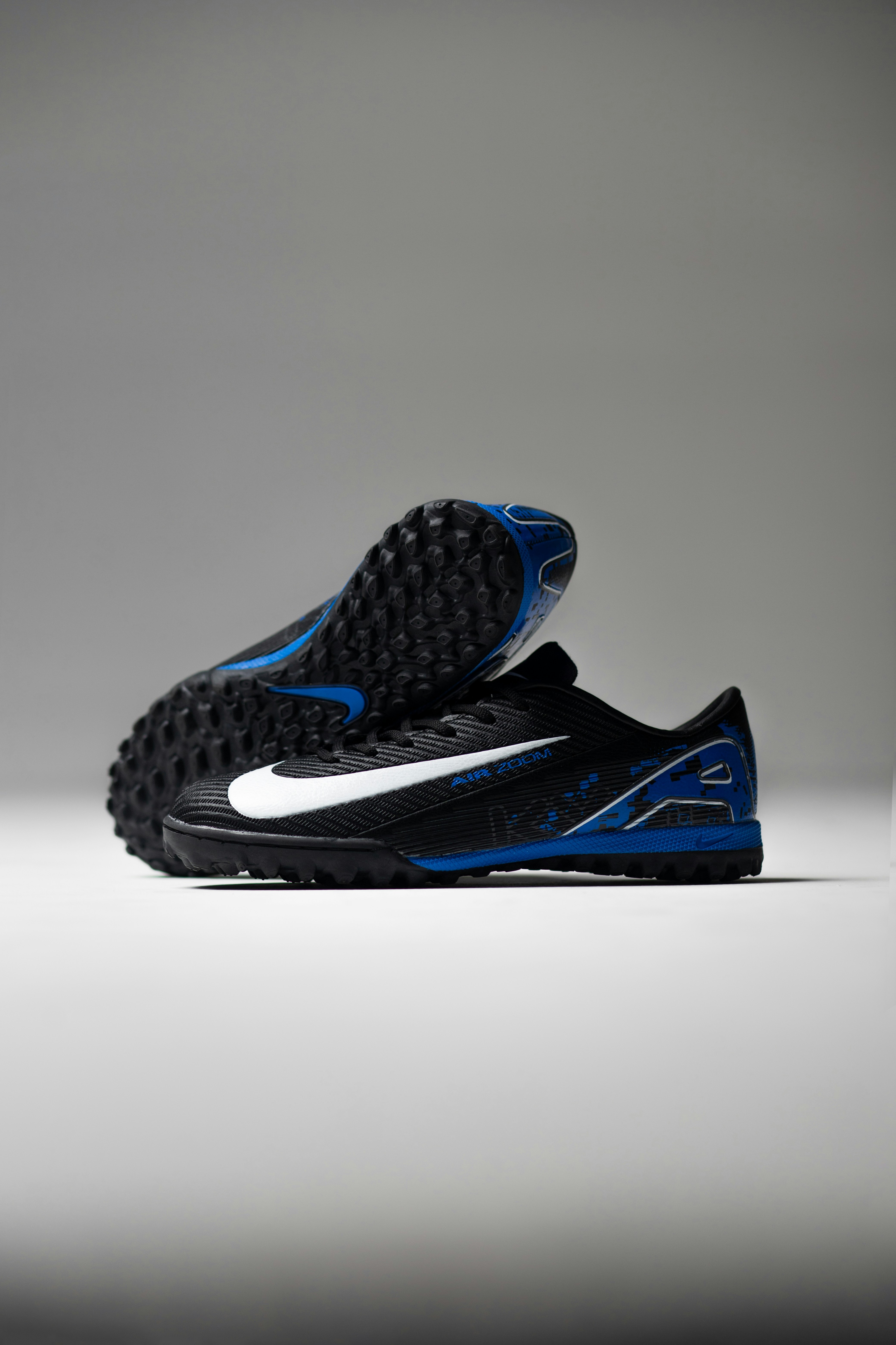 Black soccer cleats with white and blue accents