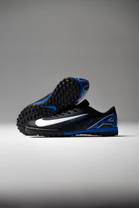 Black soccer cleats with white and blue accents