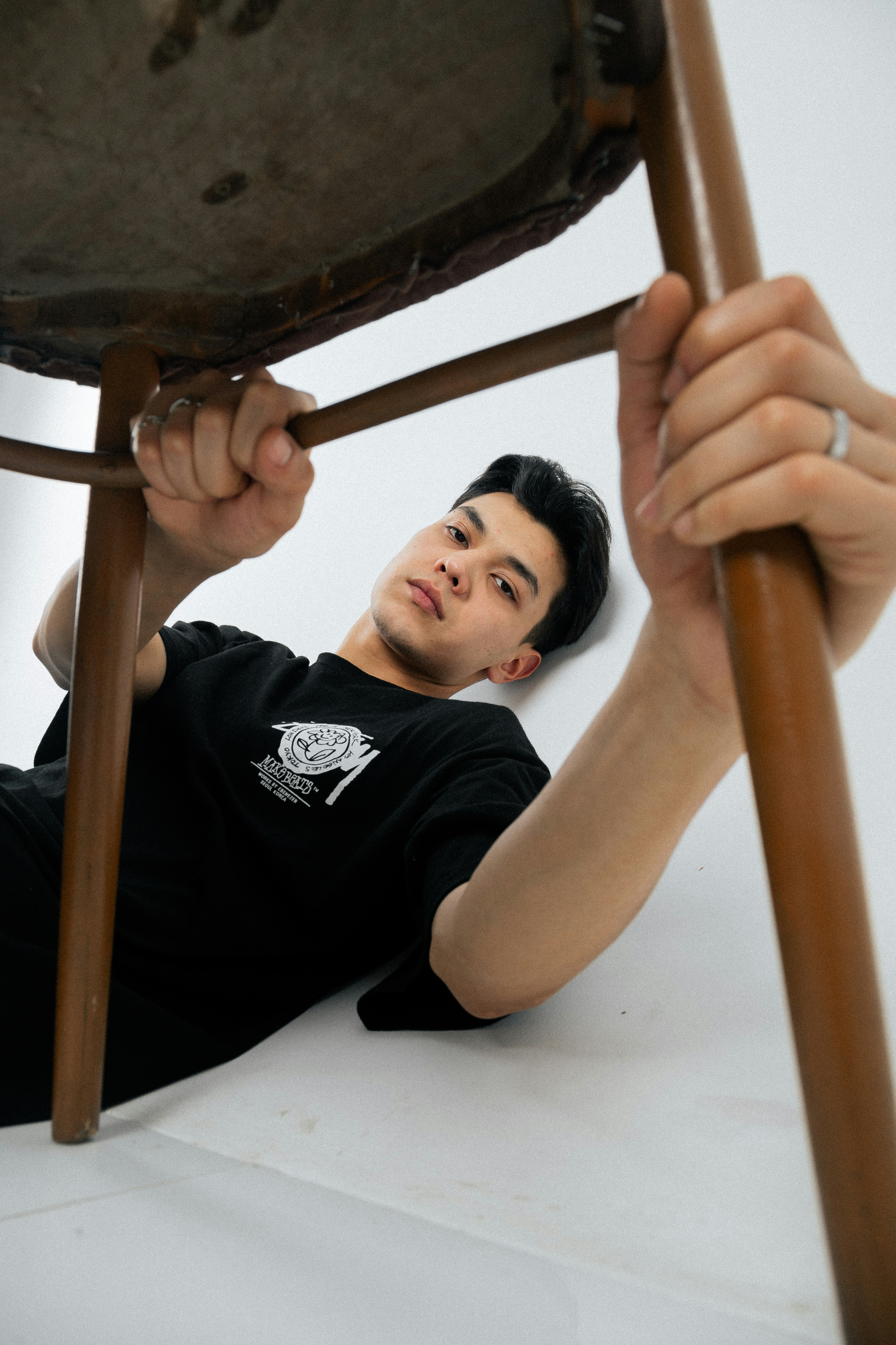 Young man looking up from under a chair