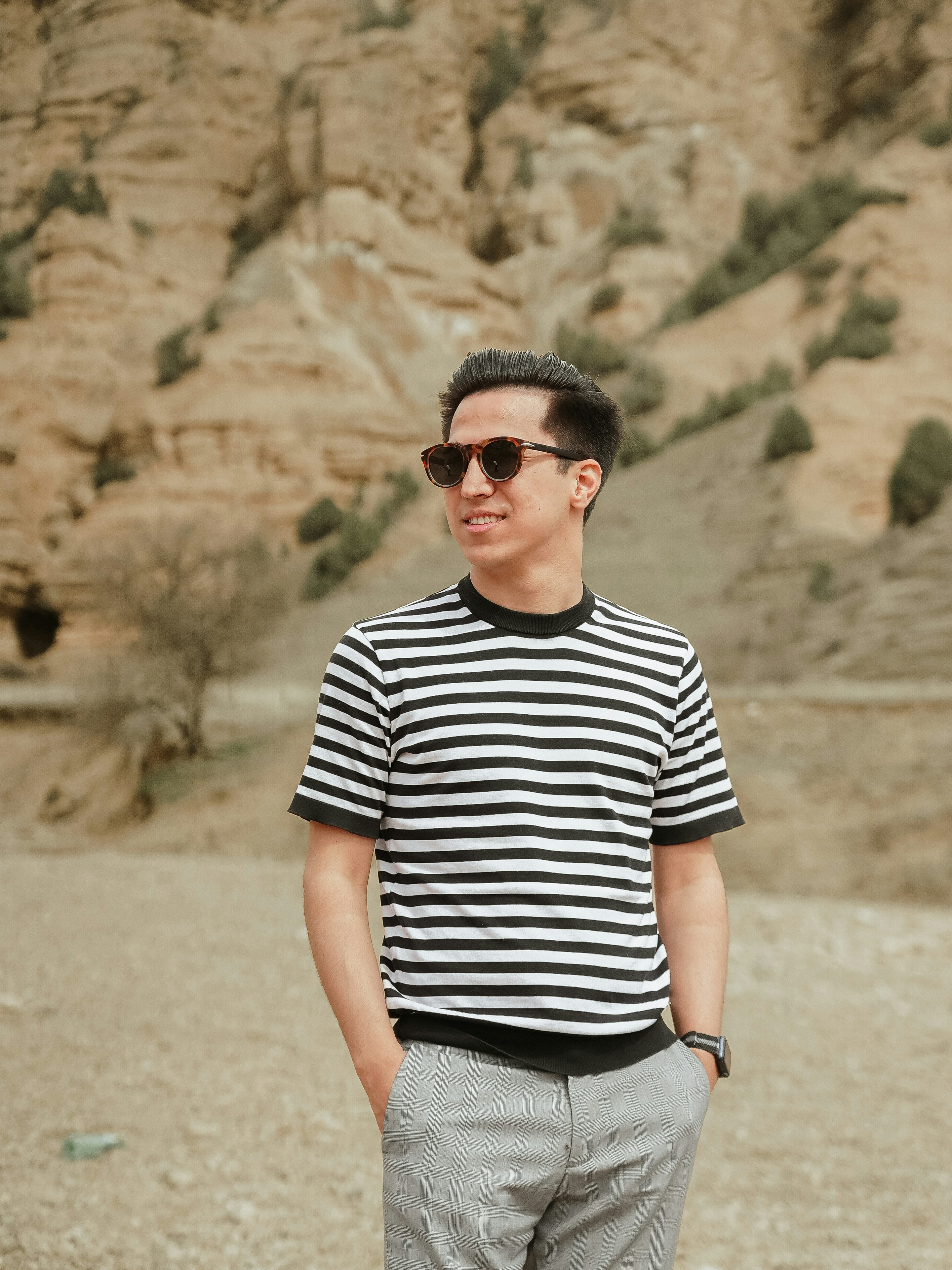 Man in striped shirt and sunglasses in desert landscape