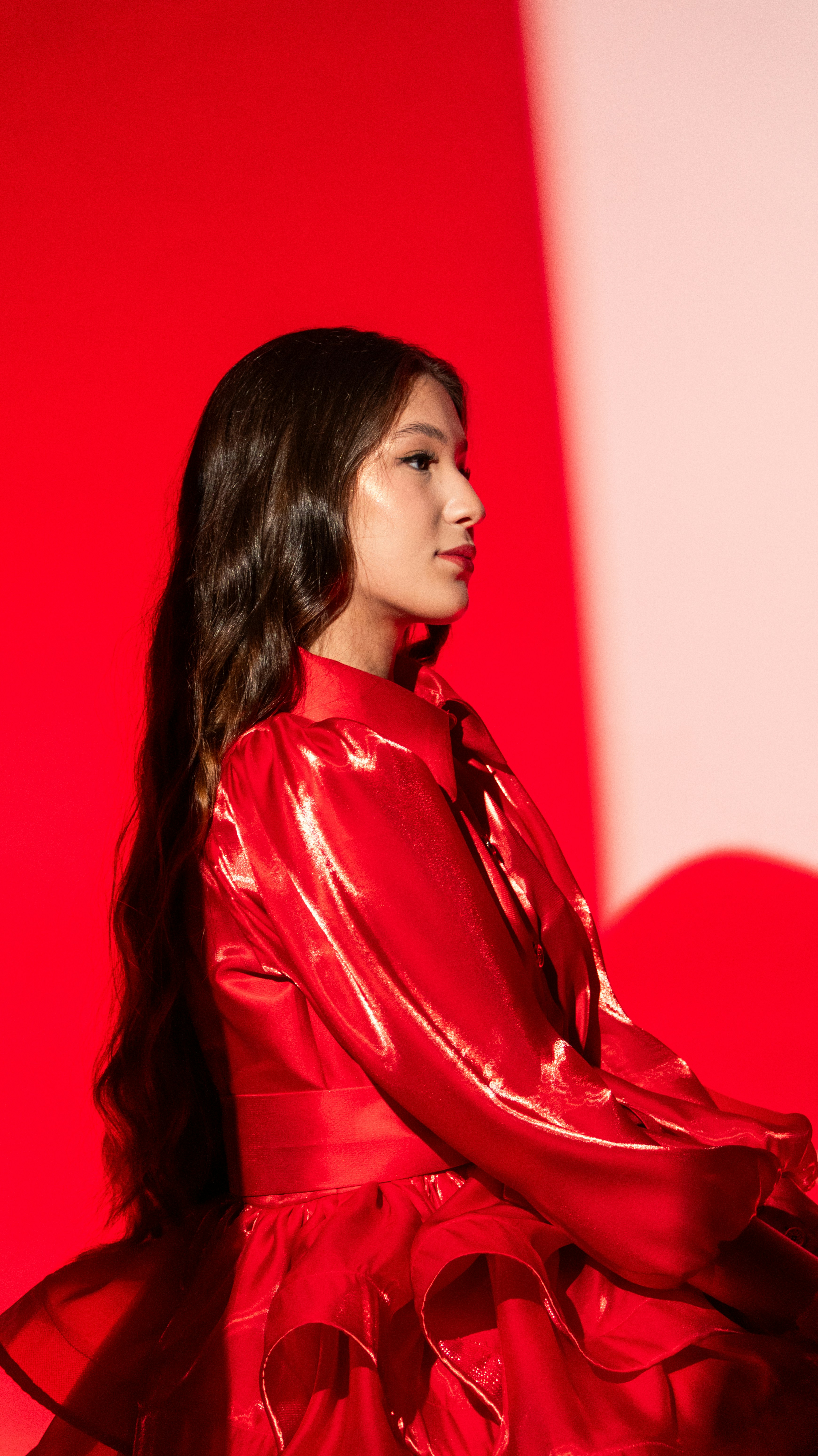 A young woman in a red dress against red background