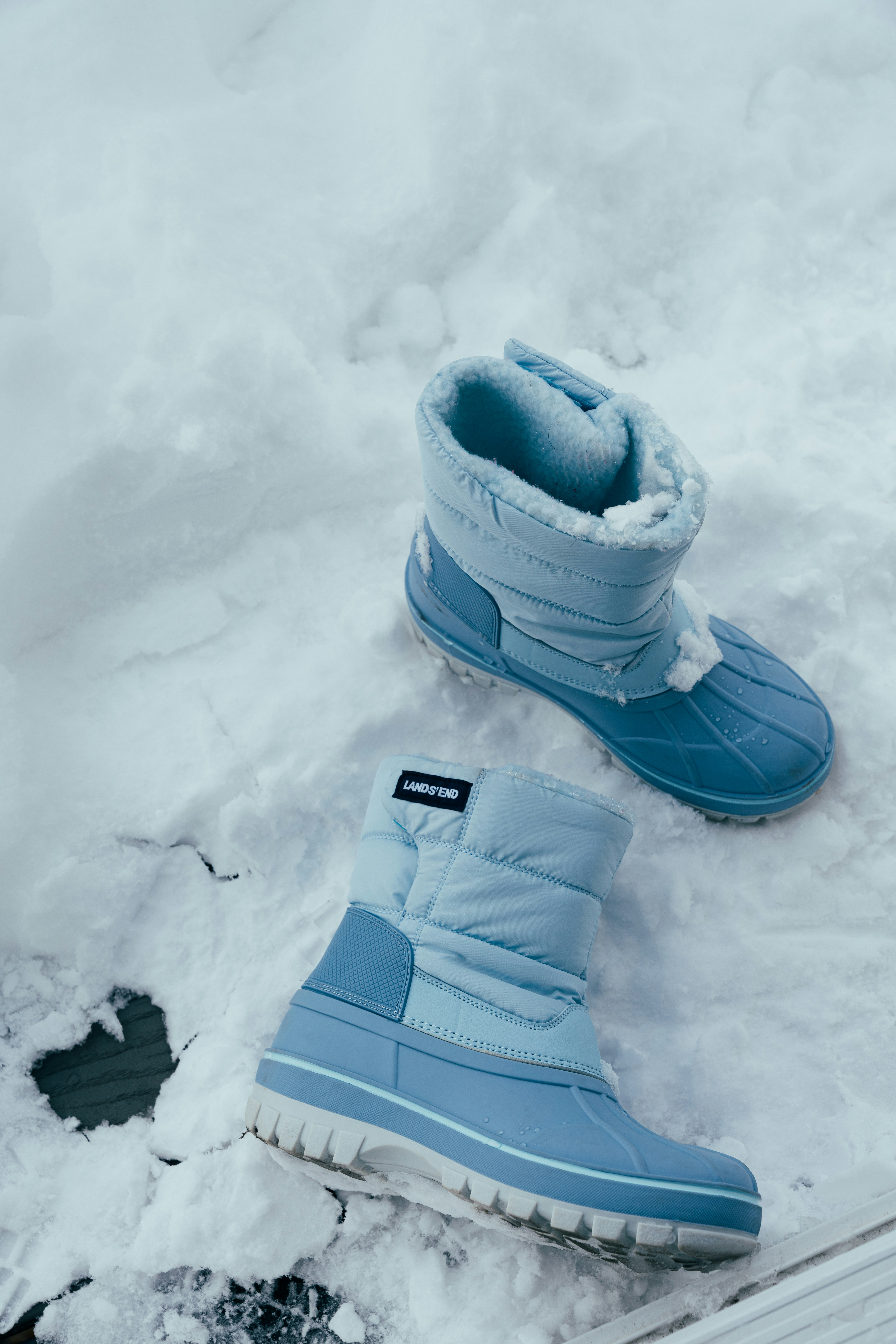 Pair of light blue winter boots in the snow