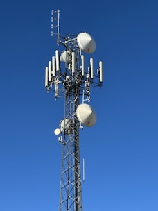 A tall telecommunications tower against a clear blue sky.