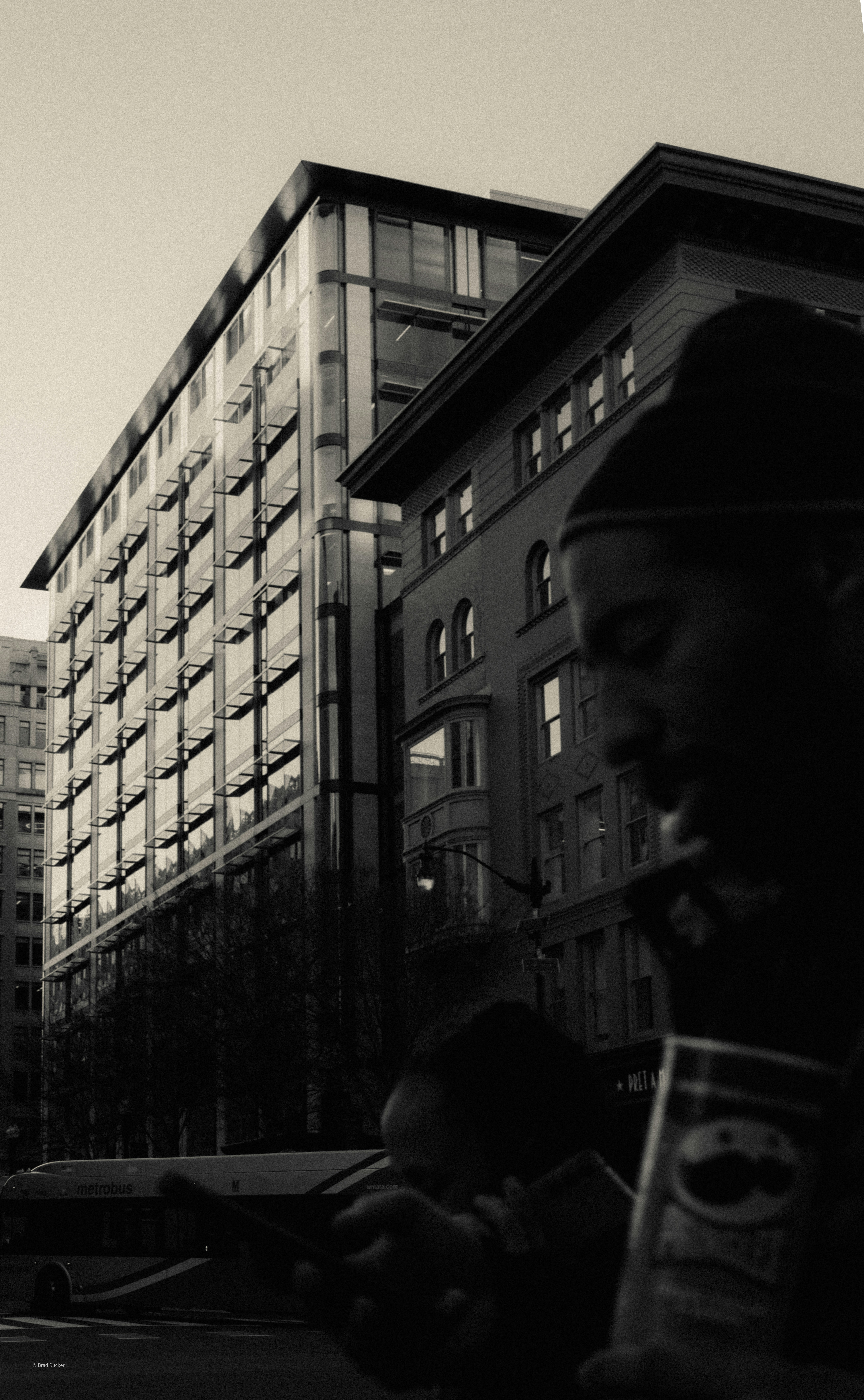 People in front of buildings with a bus in background.
