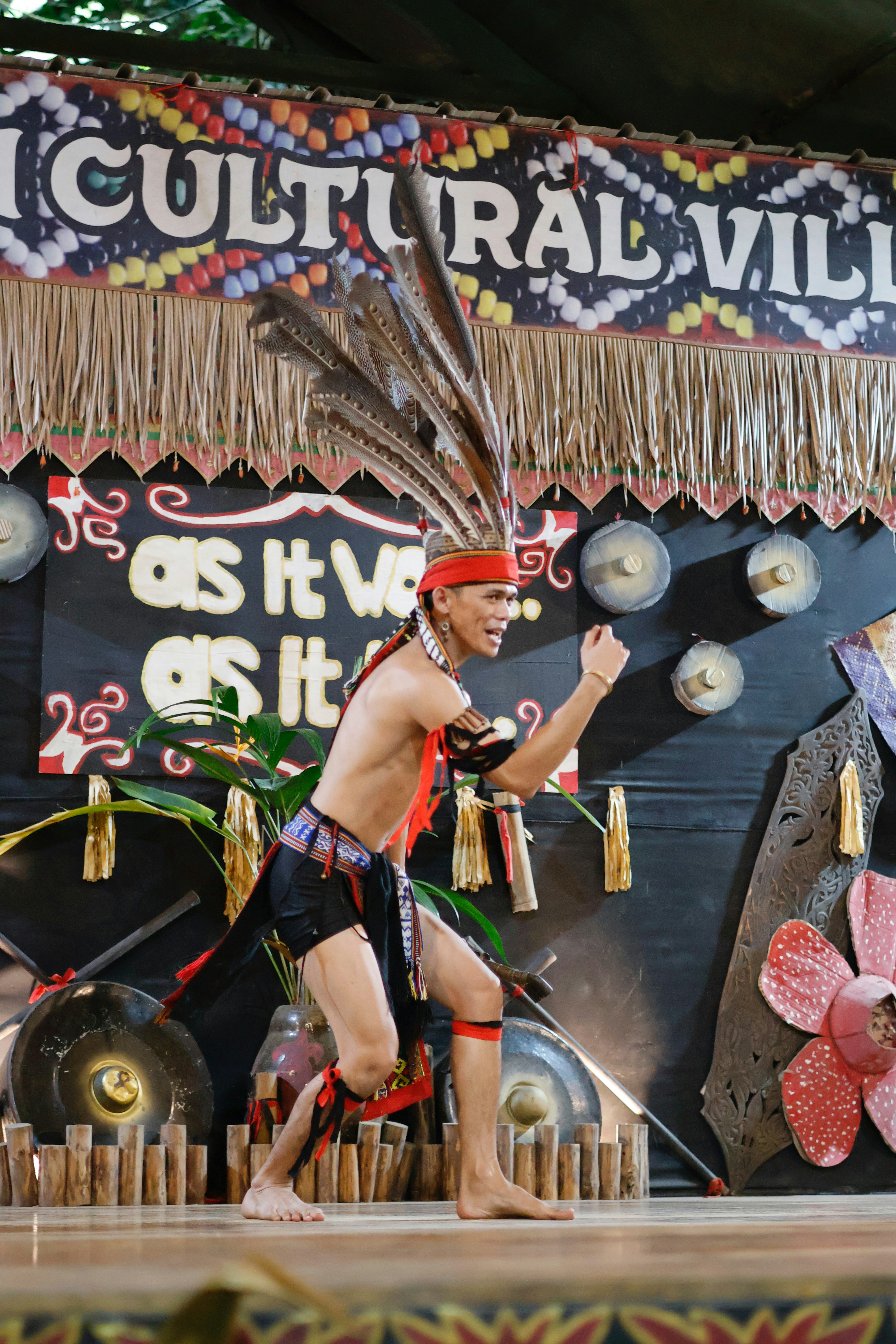 伝統的な先住民の衣装をまとった男性が踊っている