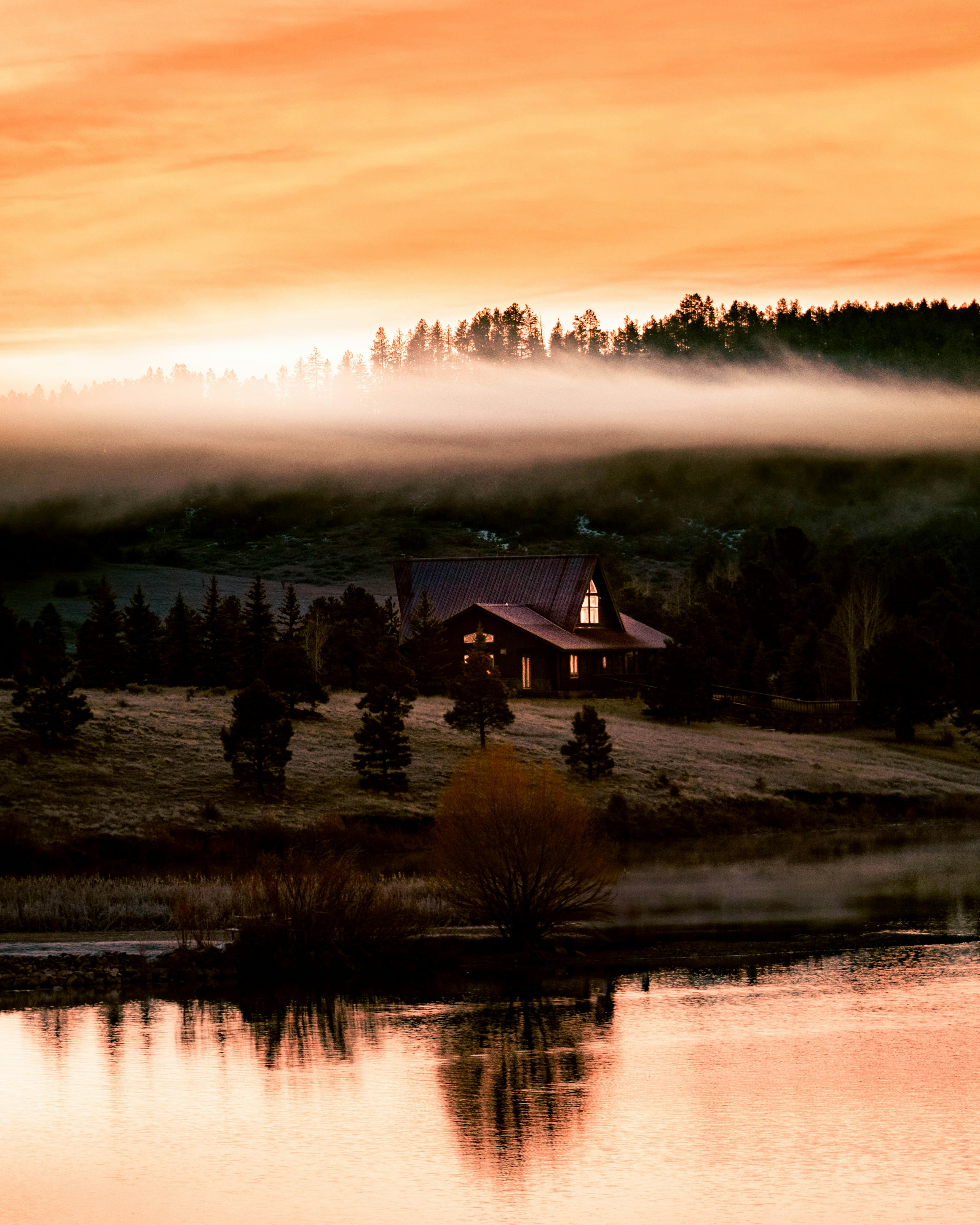 Misty morning over a serene lake and forest