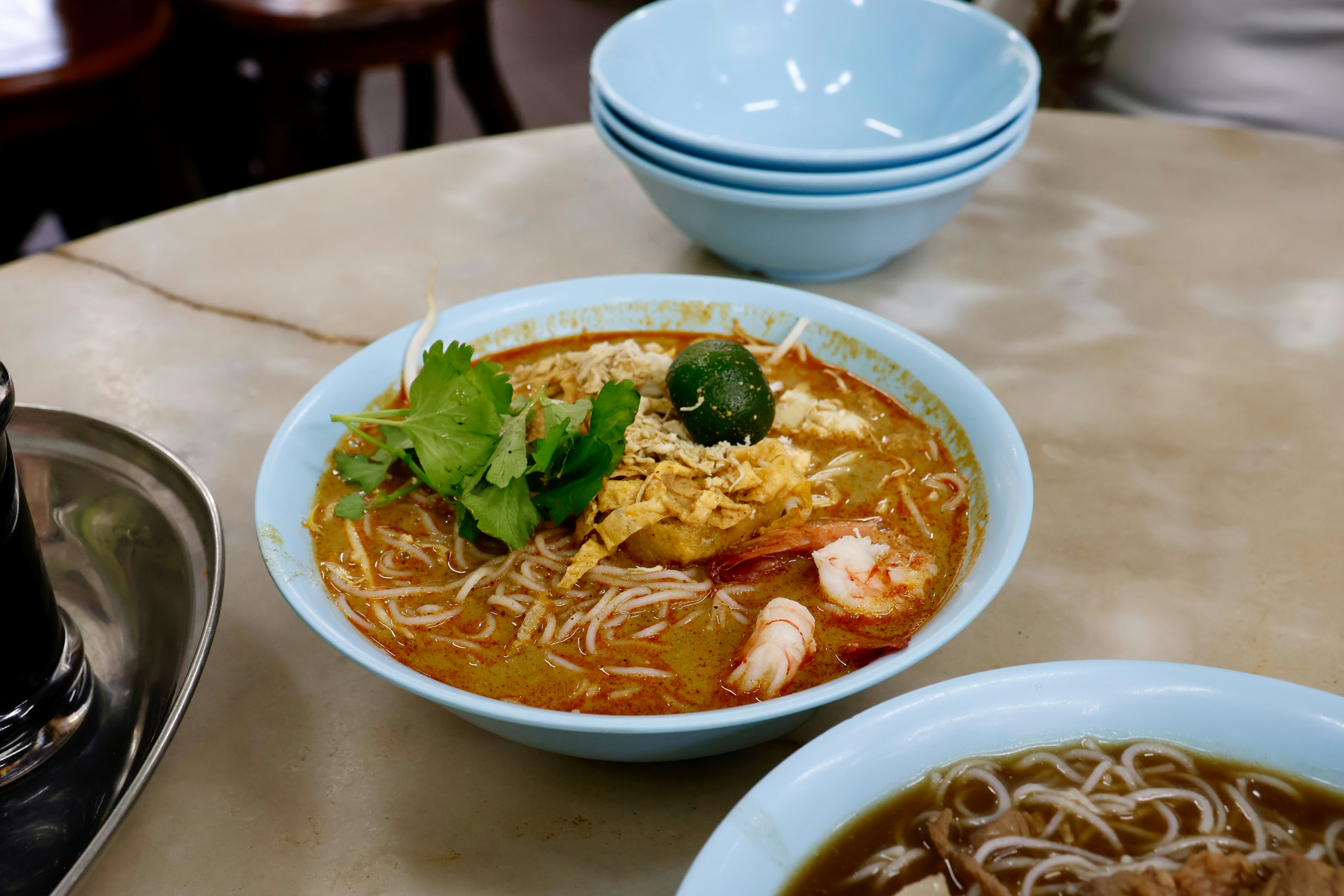 A bowl of delicious laksa soup with noodles and shrimp.