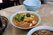 A bowl of delicious laksa soup with noodles and shrimp.