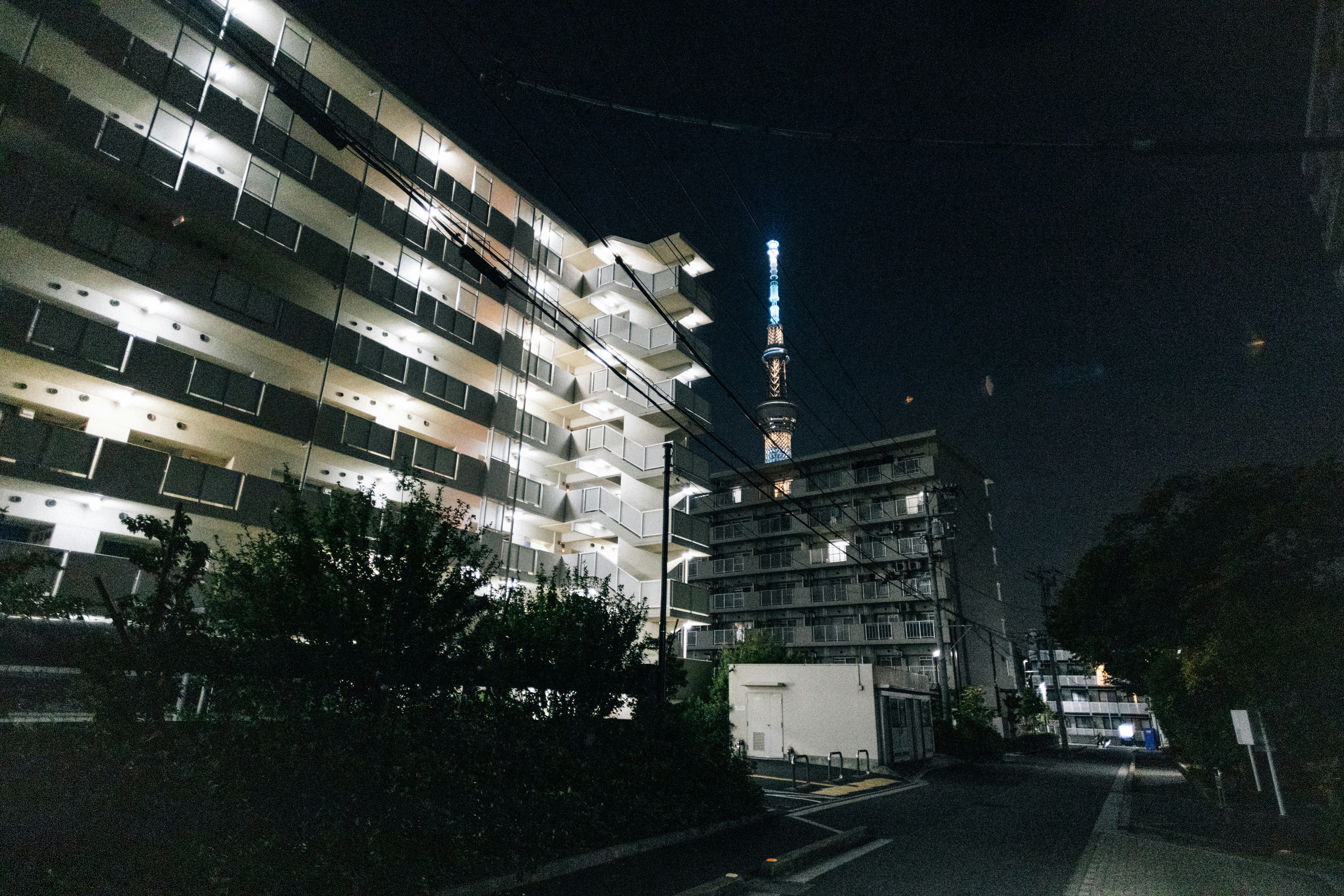 Apartment buildings at night with a distant tower.