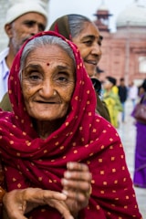 Elderly indian woman in red headscarf smiling