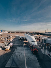 Airplane parked at the gate with service vehicles around