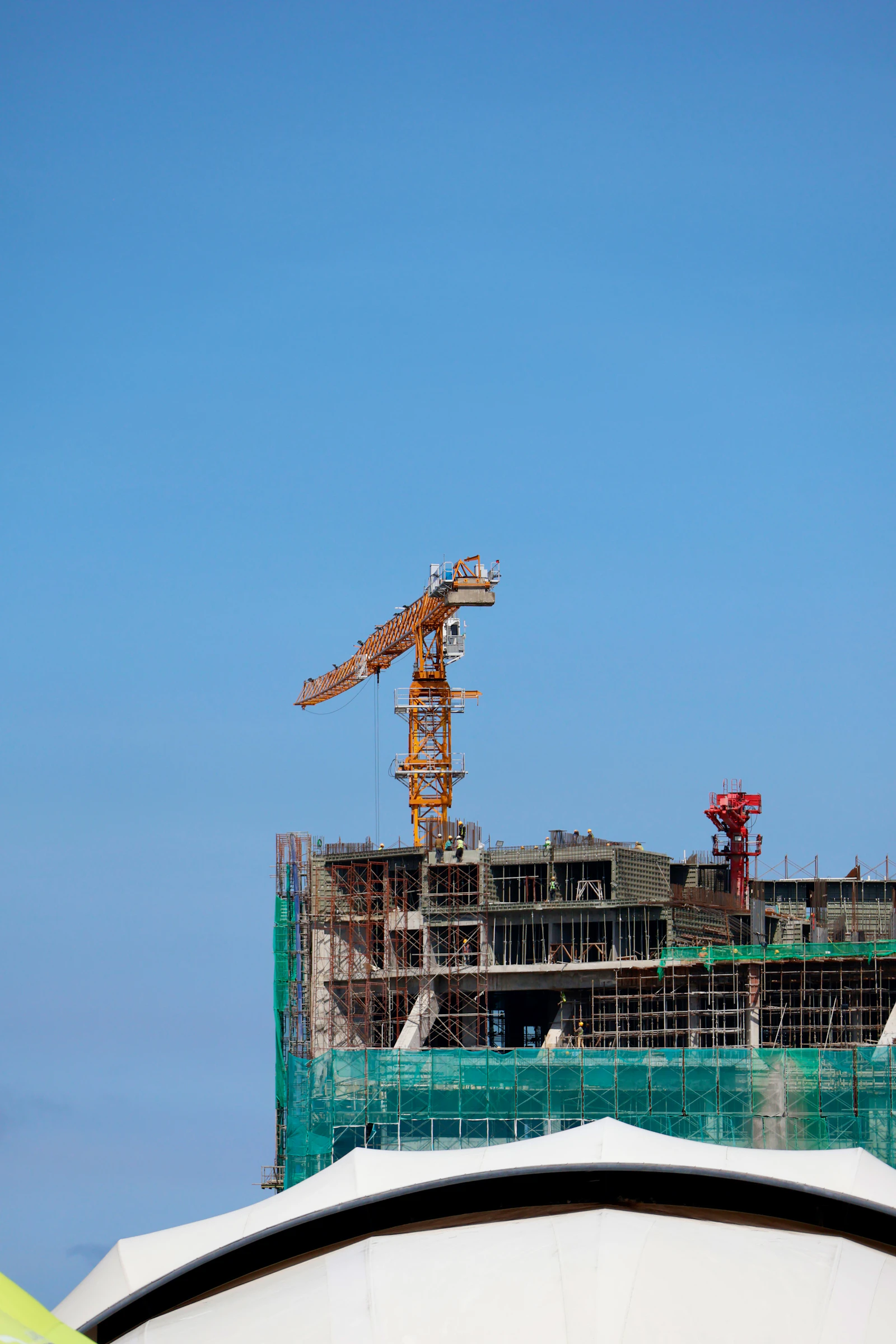 Construction crane against a clear blue sky.