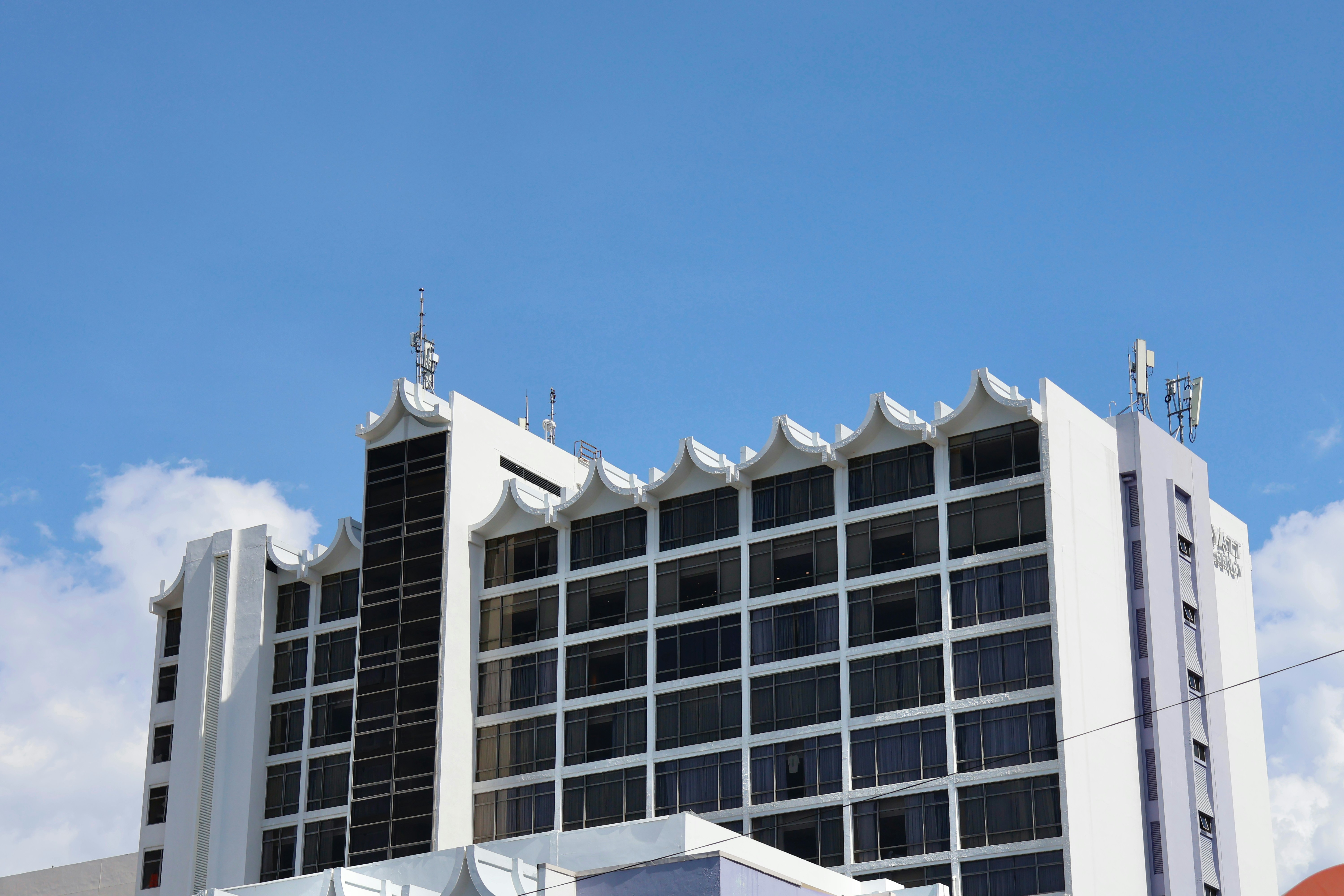 Modern white building with many windows under blue sky