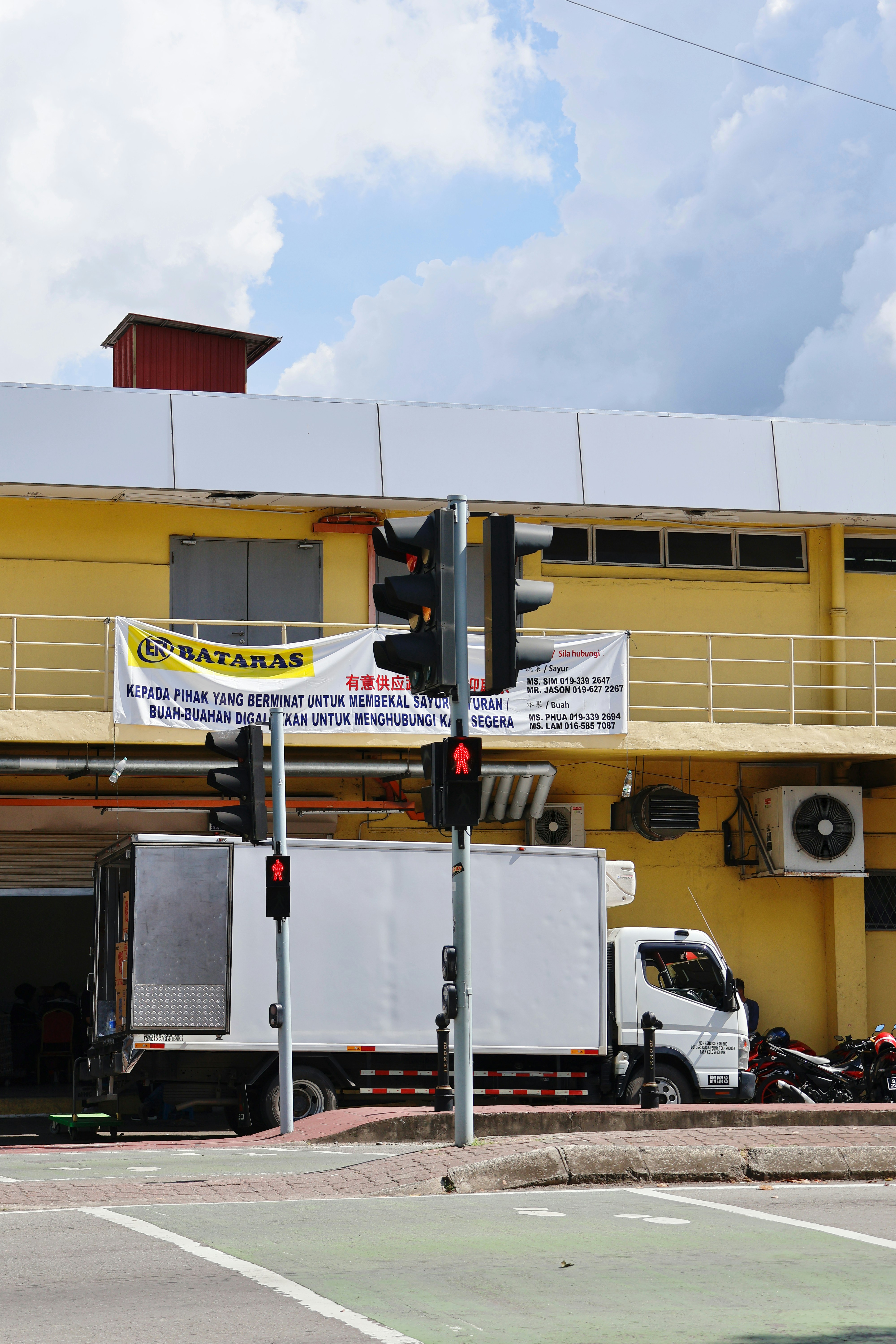 White truck parked outside yellow building with traffic lights.