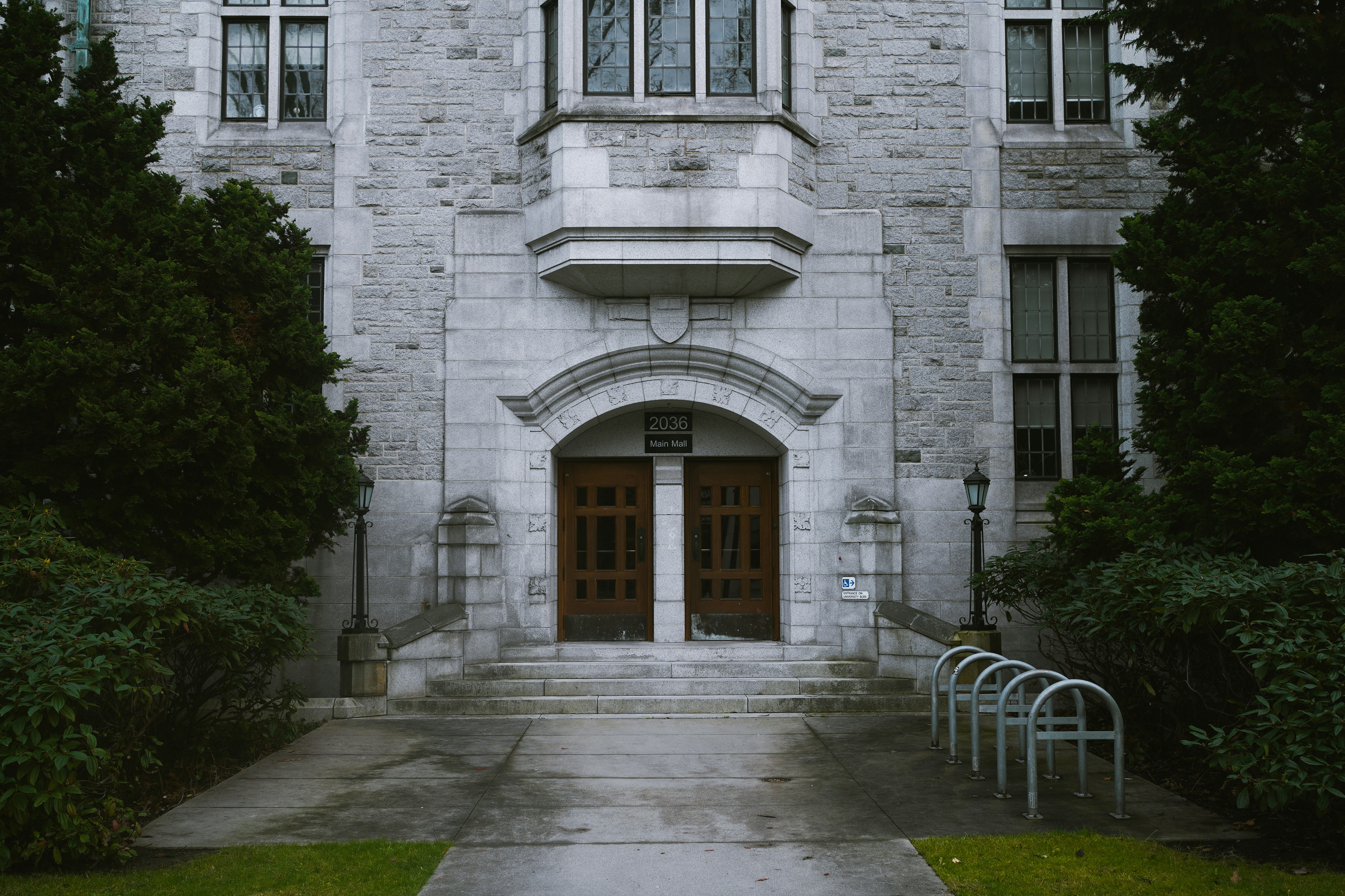 Stone school entrance with an arched doorway and bike racks