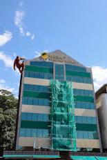 Man in orange suit scaling a building