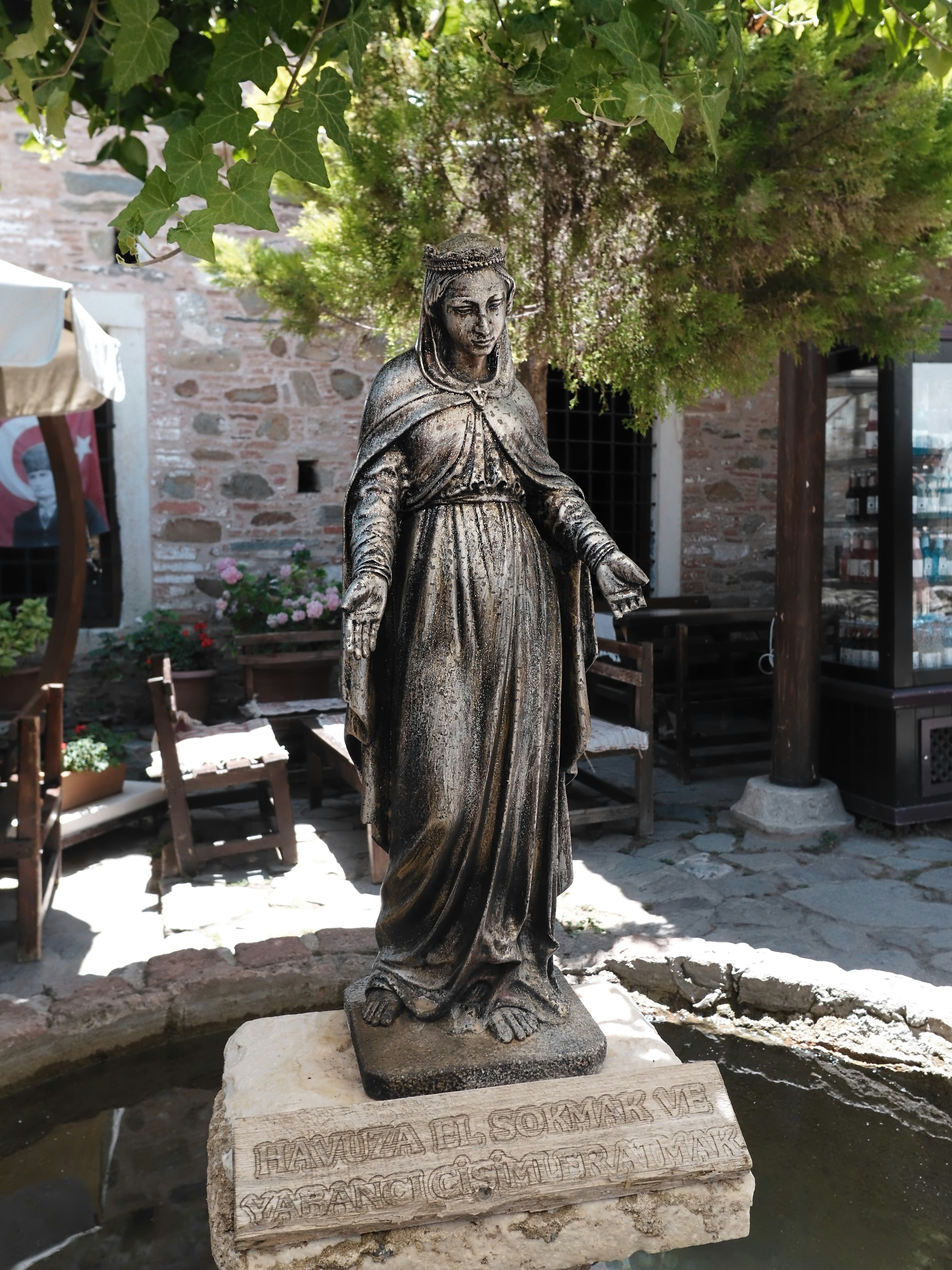A bronze statue of a robed woman with a crown.