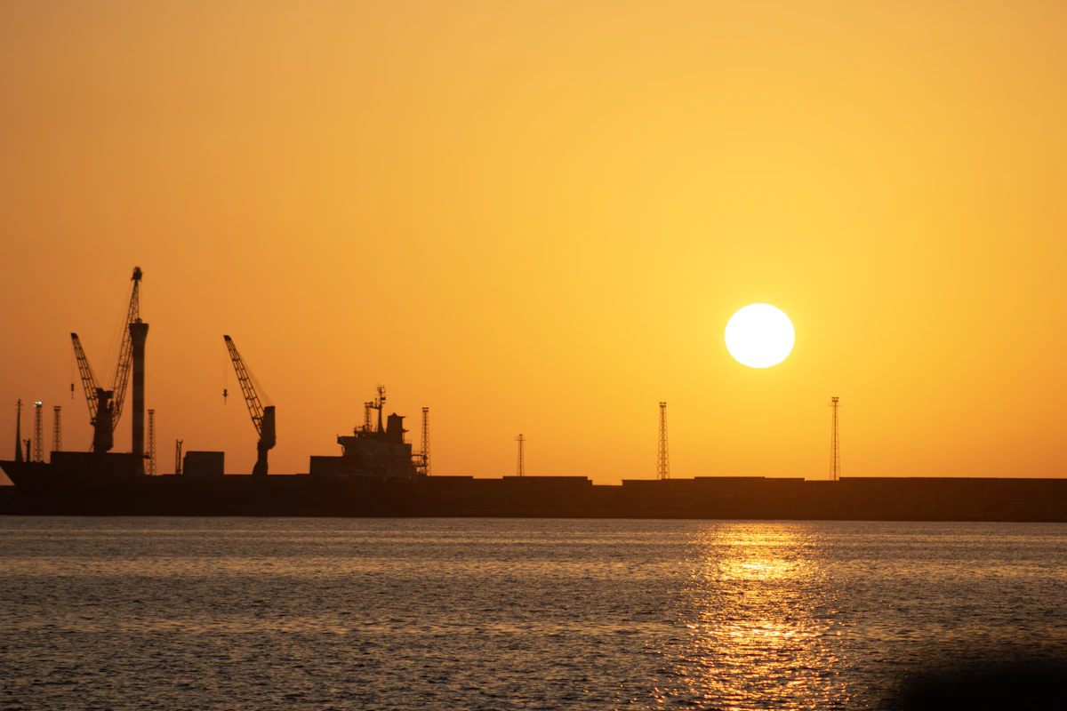 Sunset over Tripoli port with ships and cranes