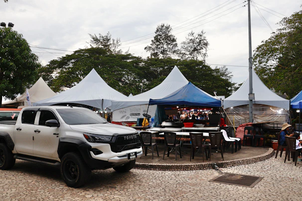 White pickup truck parked near outdoor market stalls