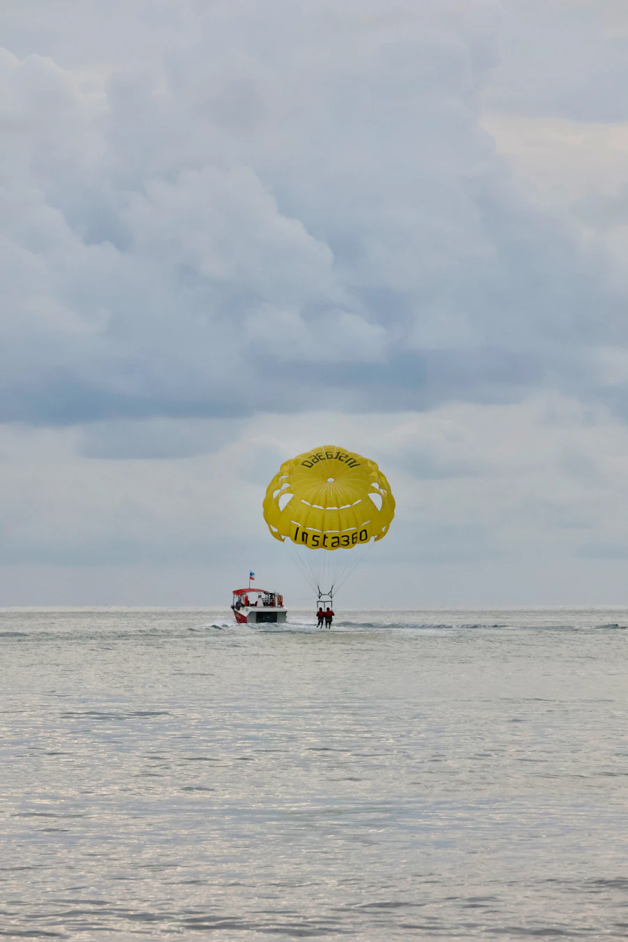 Parasailing canopy high above the ocean with boat below