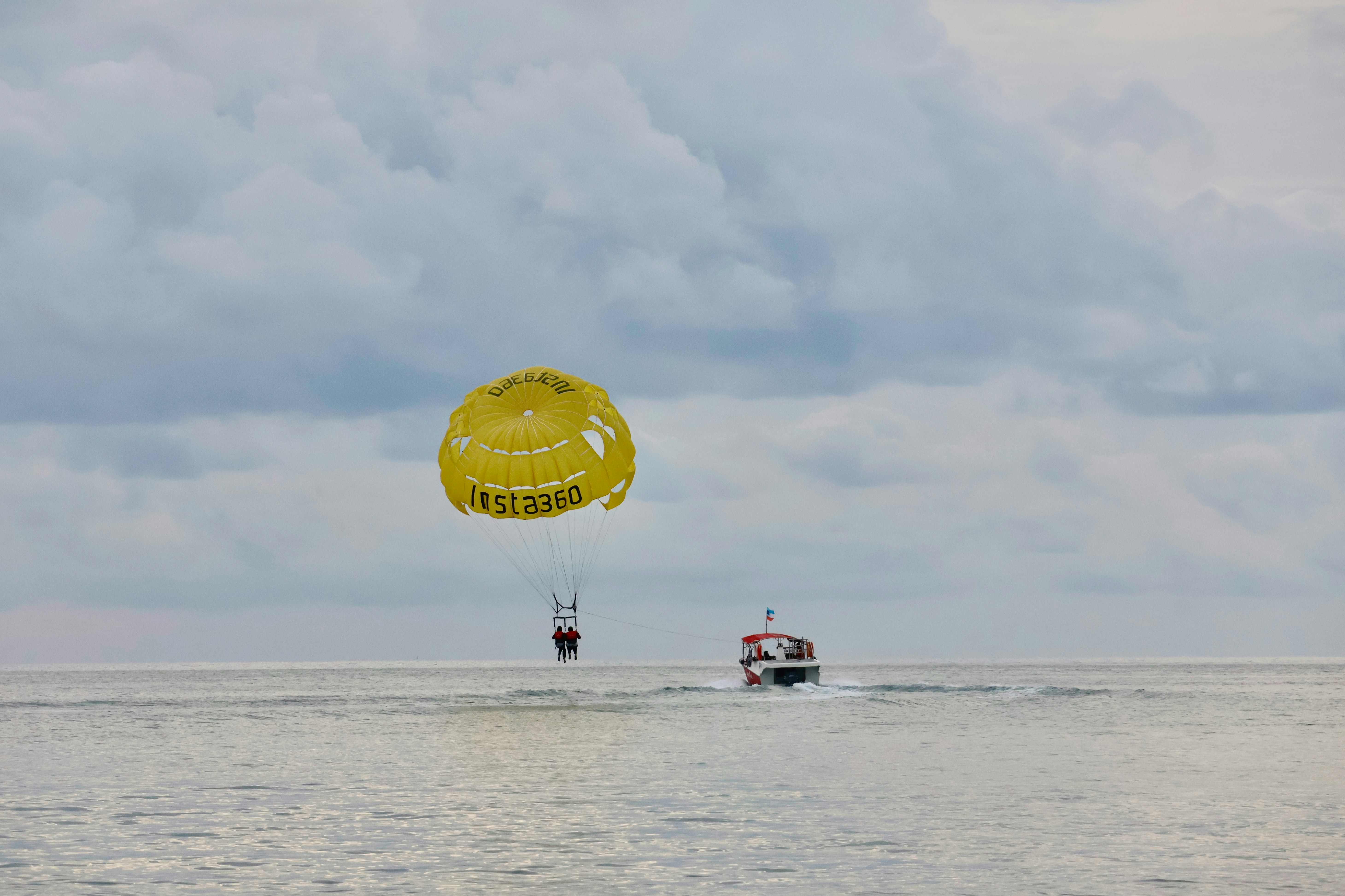 People parasailing behind a boat on the ocean
