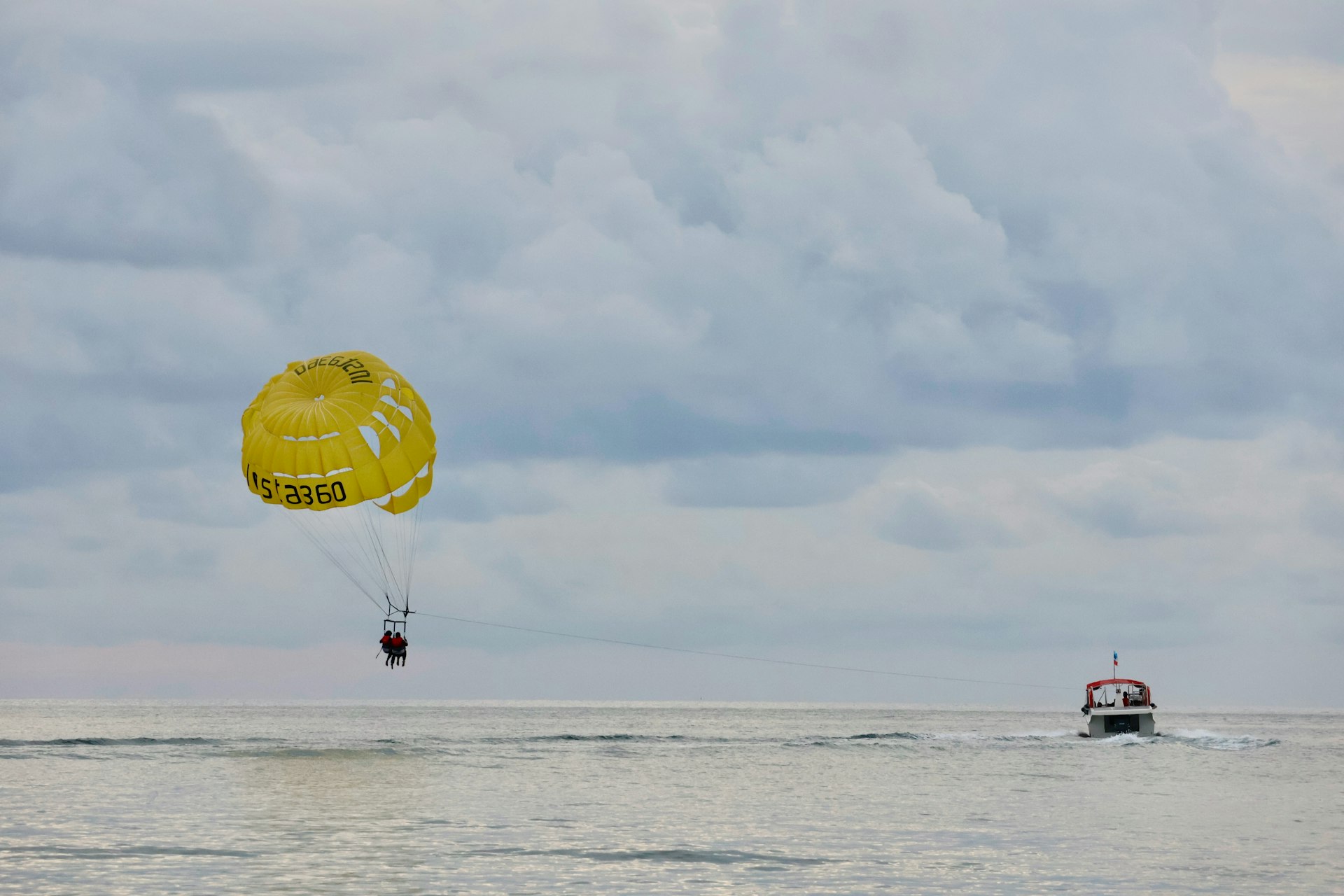 Parasailing over the ocean with a boat in distance