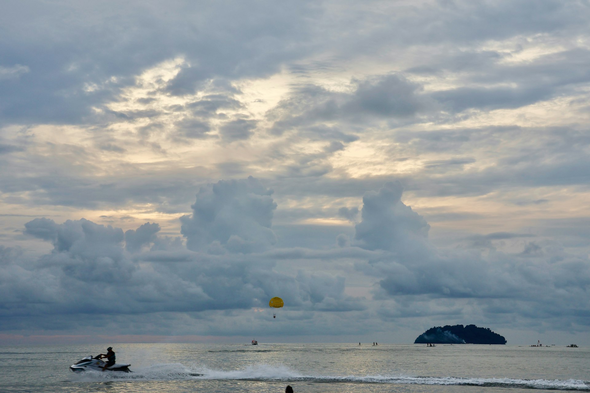 Jet ski and parasail on the ocean at dusk